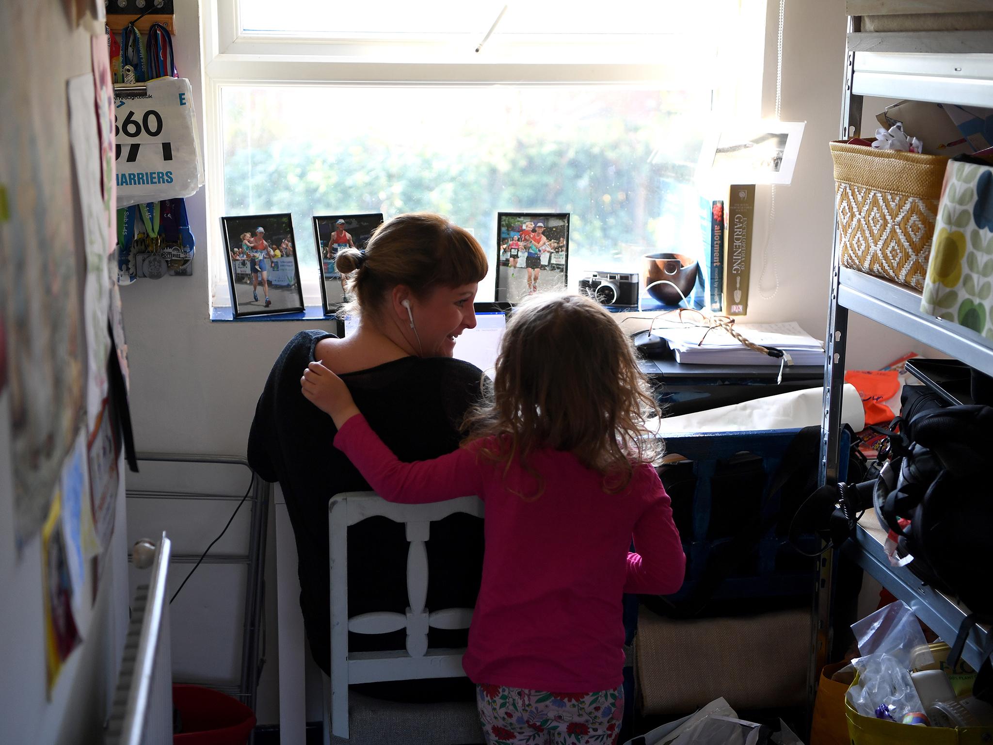 Four-year-old Lois Copley-Jones disturbs her mother Ruth, who is pictured working from home in Newcastle Under Lyme in March