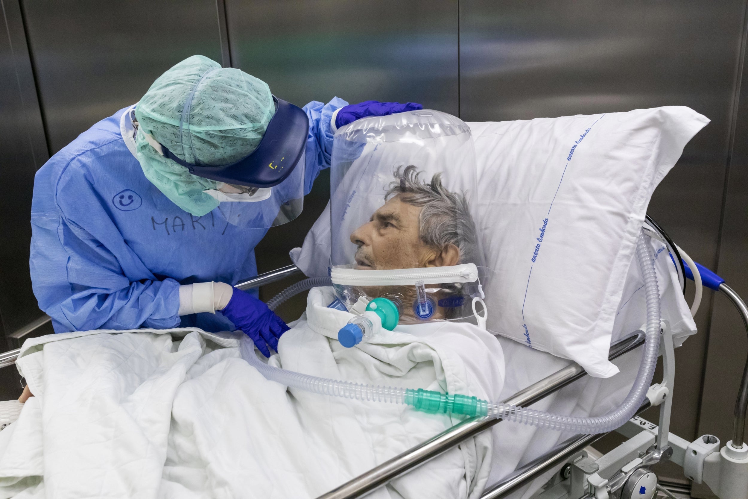 A nurse wears a CPAP helmet while attending to a patient being moved out of the ICU in the Pope John XXIII Hospital in Bergamo (Getty)