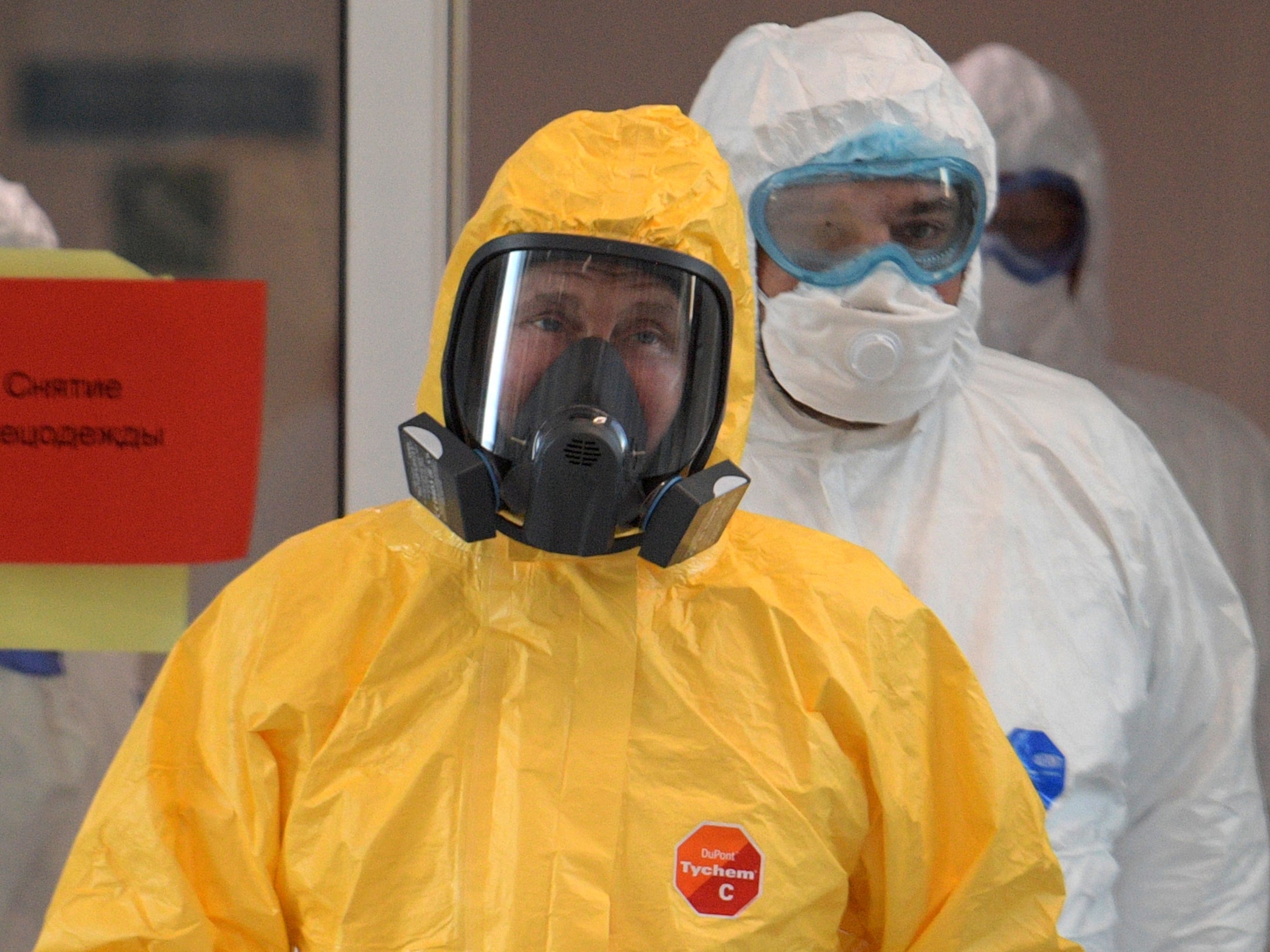 Vladimir Putin donning protective gear to visit a hospital with patients treated for Covid-19