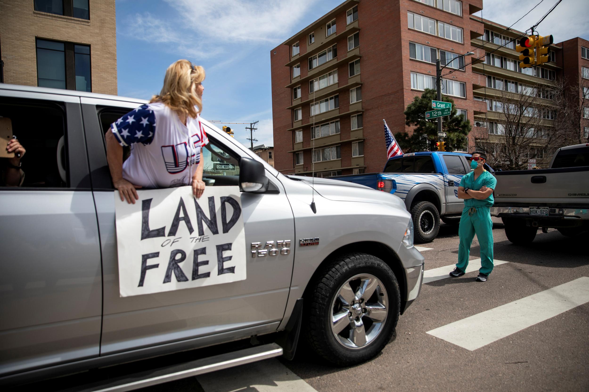 In Colorado on Sunday, health workers in PPE blocked the way of some demonstrators demanding the end of the lockdown