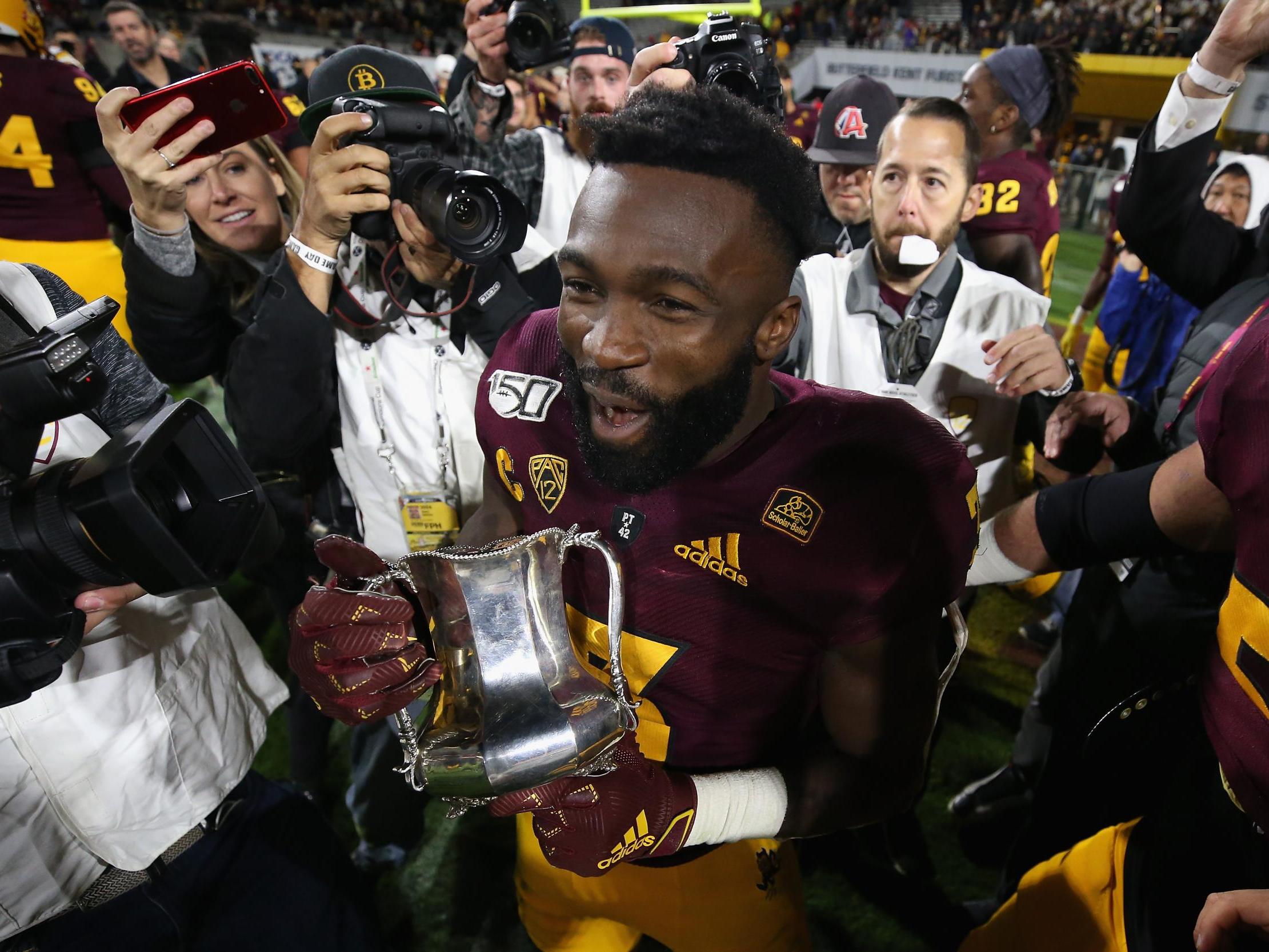 Running back Eno Benjamin celebrates with the Territorial Cup