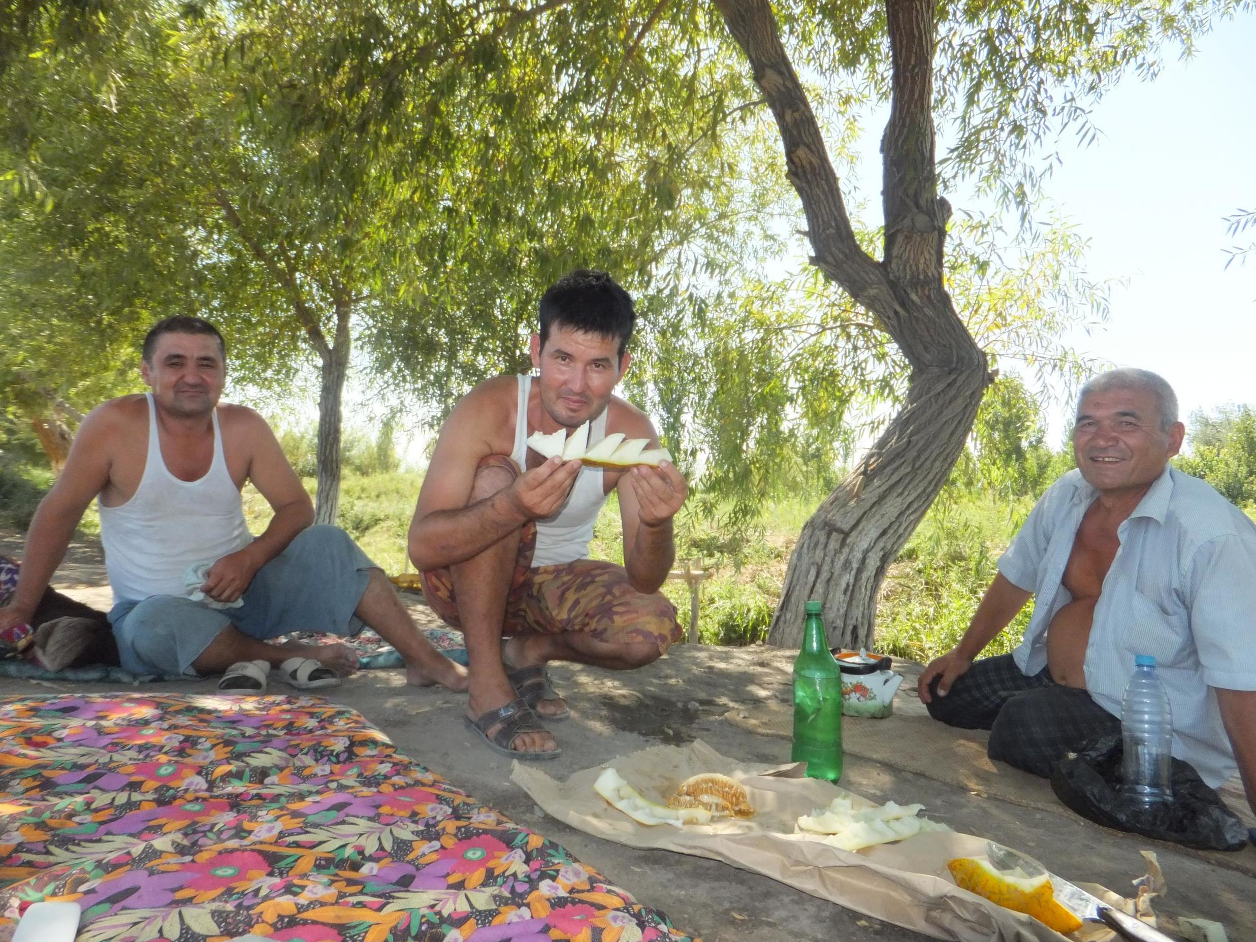 Three Uzbek men kindly give a tired cyclist some melon