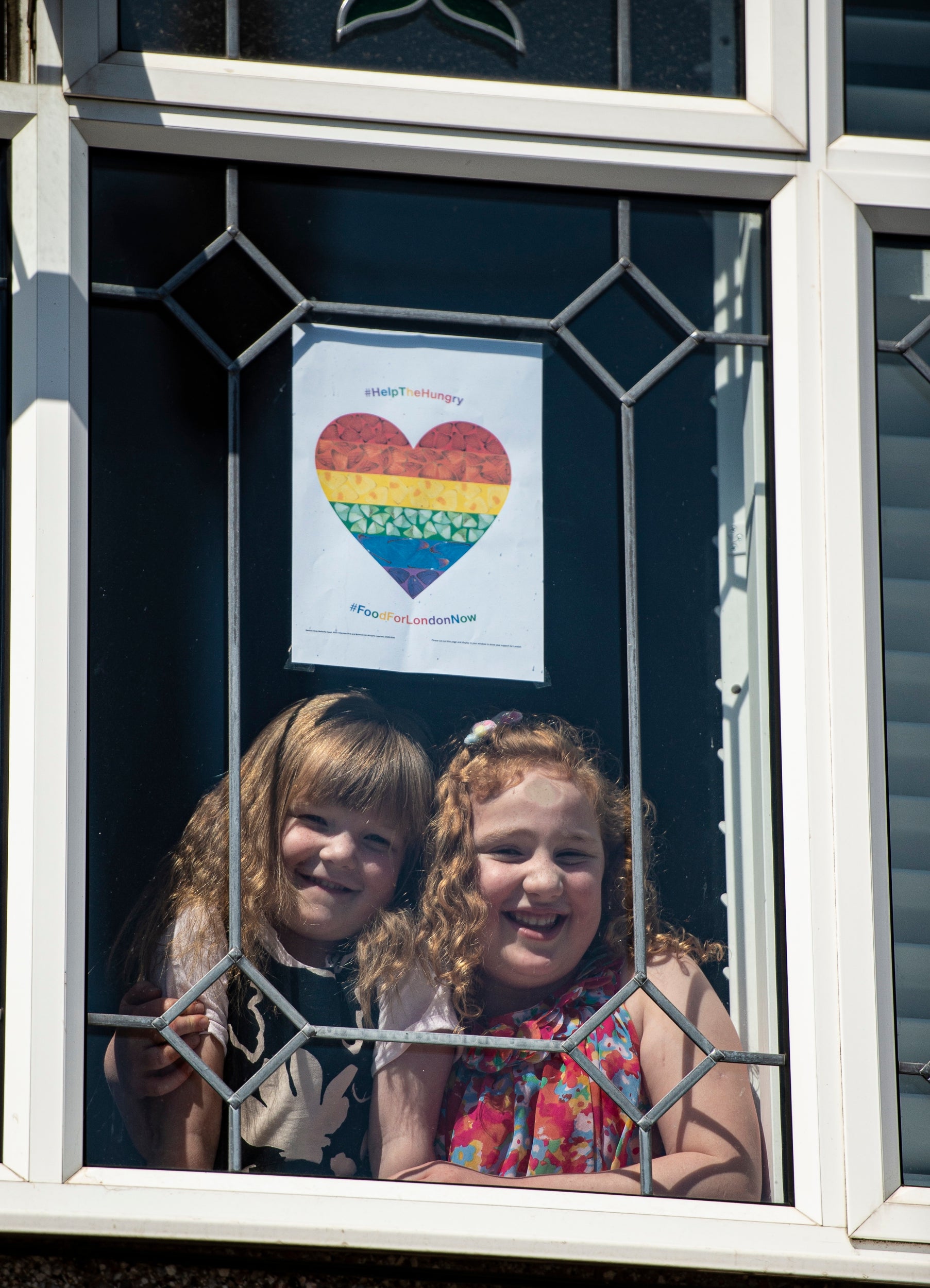 Elise and Josie pose with their poster at their Carshalton home