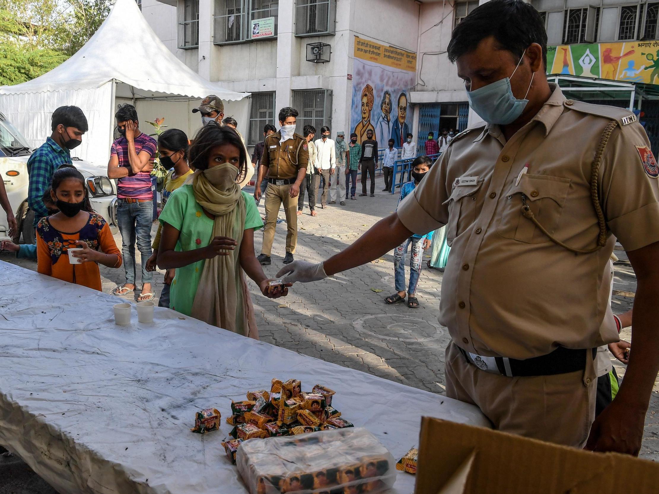 Migrant labourers get tea and refreshment at a camp set up by Delhi Government, after the fear of lockdown-induced hunger sparked an exodus of hundreds of thousands of people