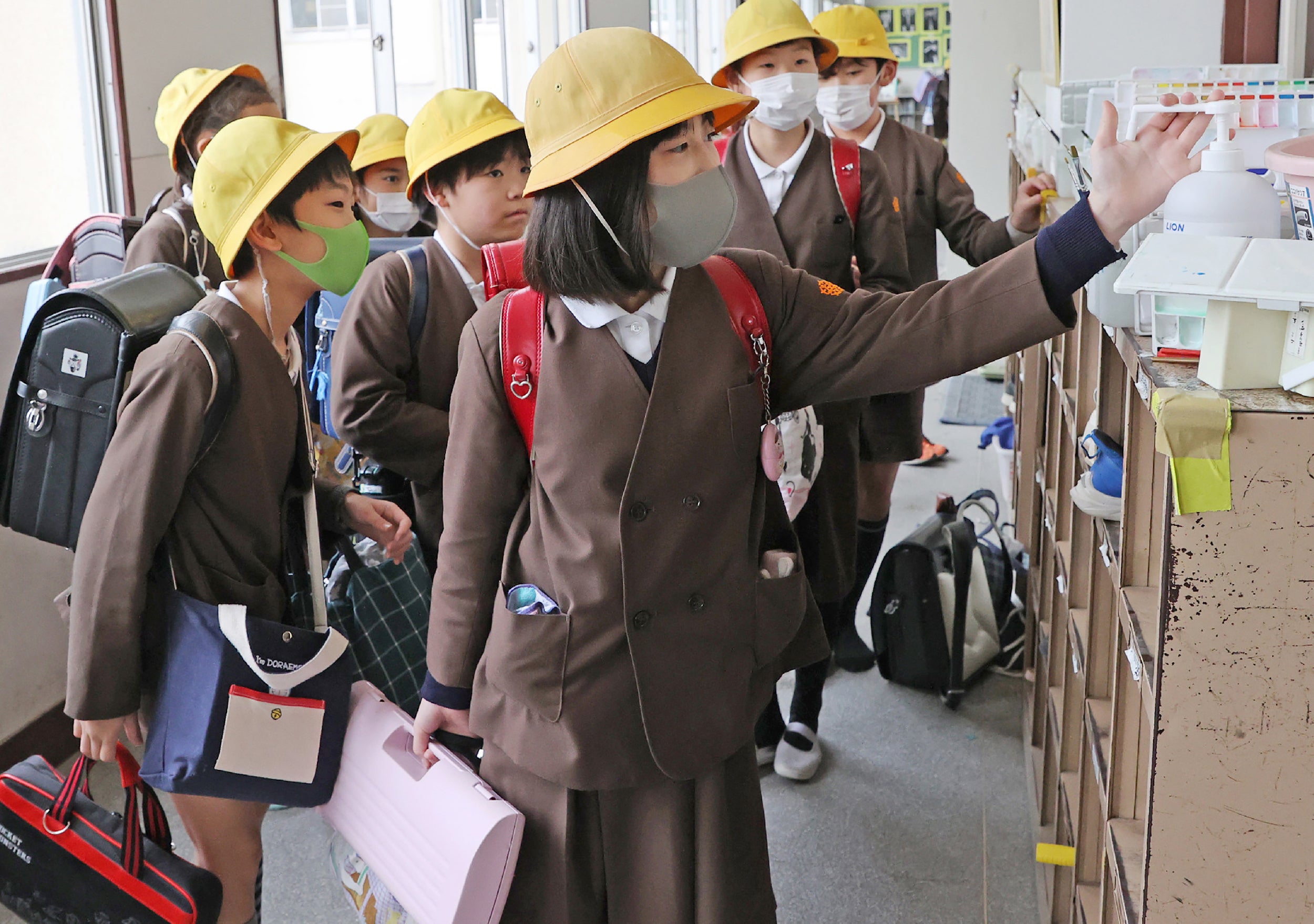 Children disinfect their hands before leaving school in Osaka