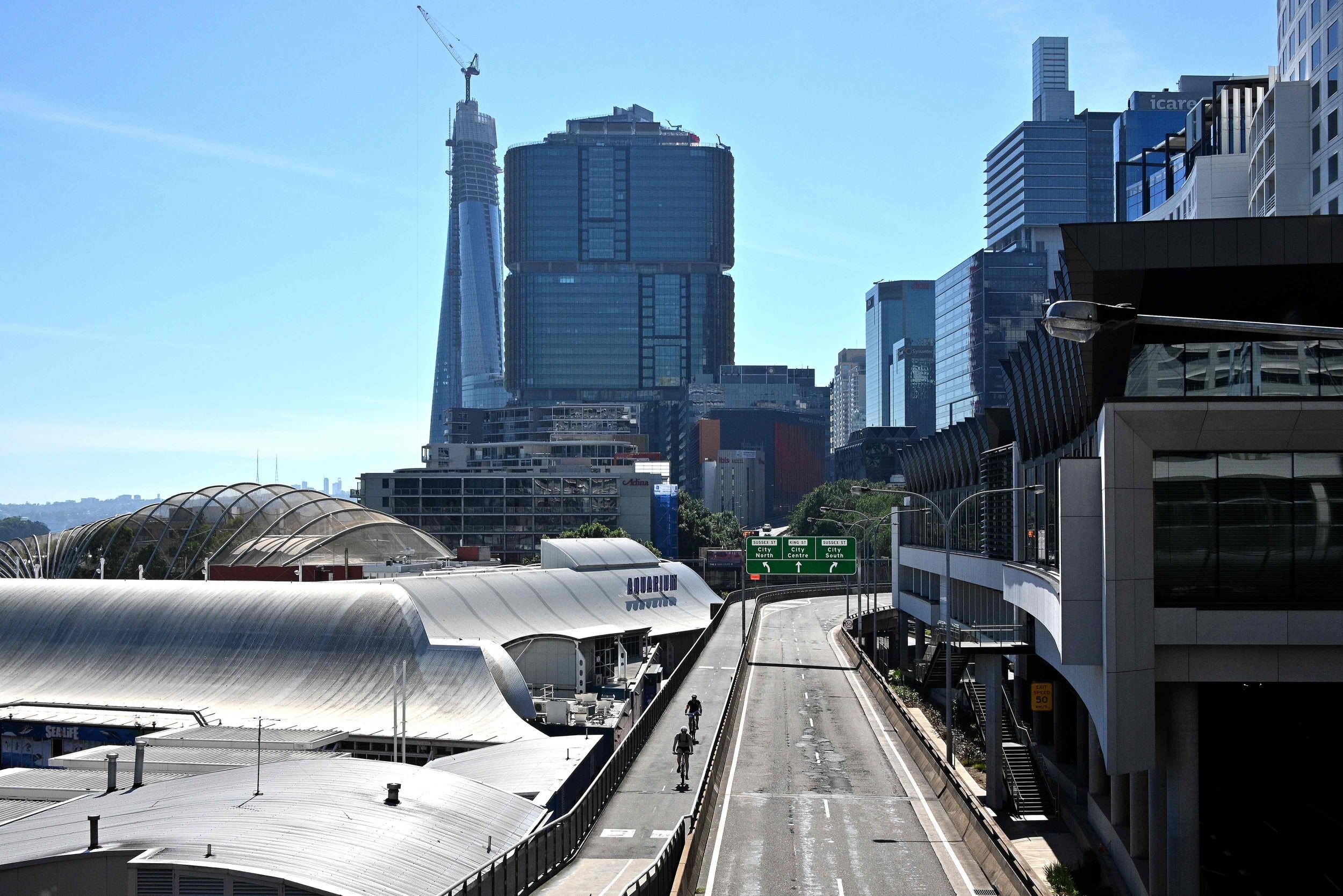 Lockdown: two cyclists bike through the empty streets of central Sydney