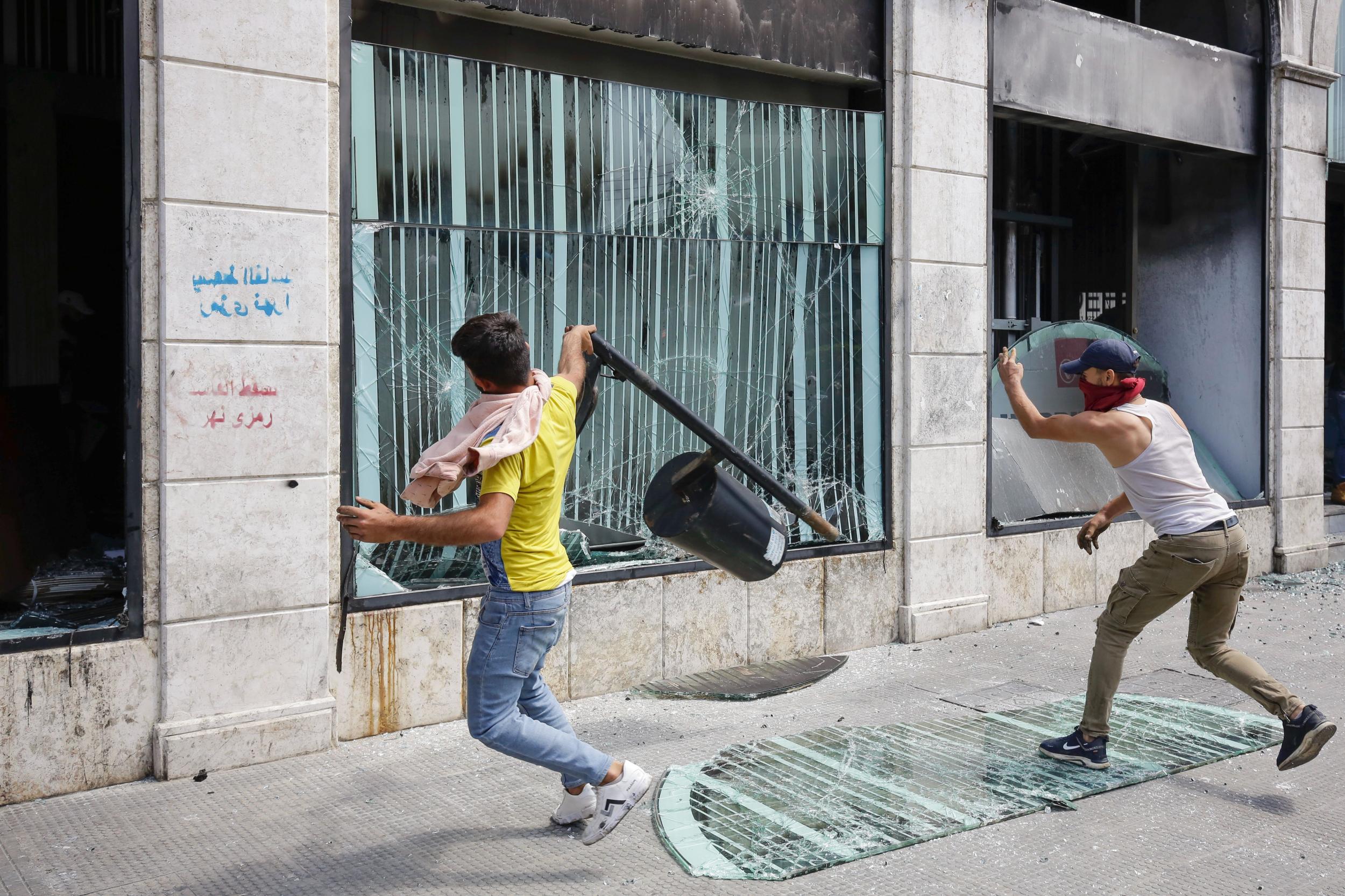 &#13;
Protesters attack a bank in Tripoli following the funeral of Fawwaz Fouad Al-Seman ​on Tuesday (AFP/Getty)&#13;