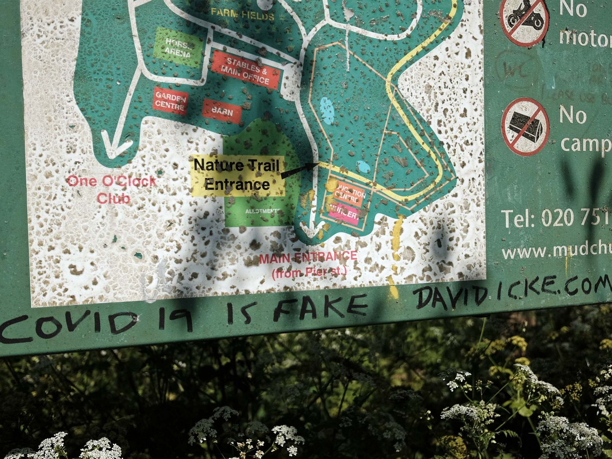 Graffiti scrawled on an information sign at Mudchute Farm on the Isle of Dogs, east London