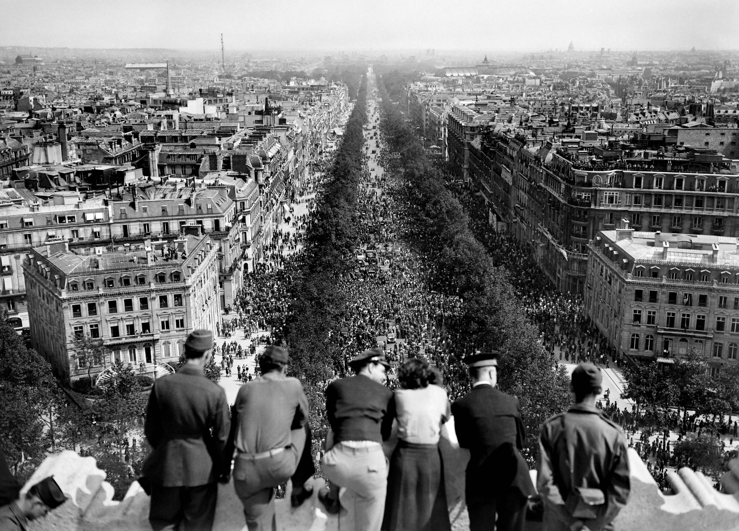 People look at the crowded Champs Elysees Avenue from the Arc de Triomphe as Parisians gather in the streets of the French capital