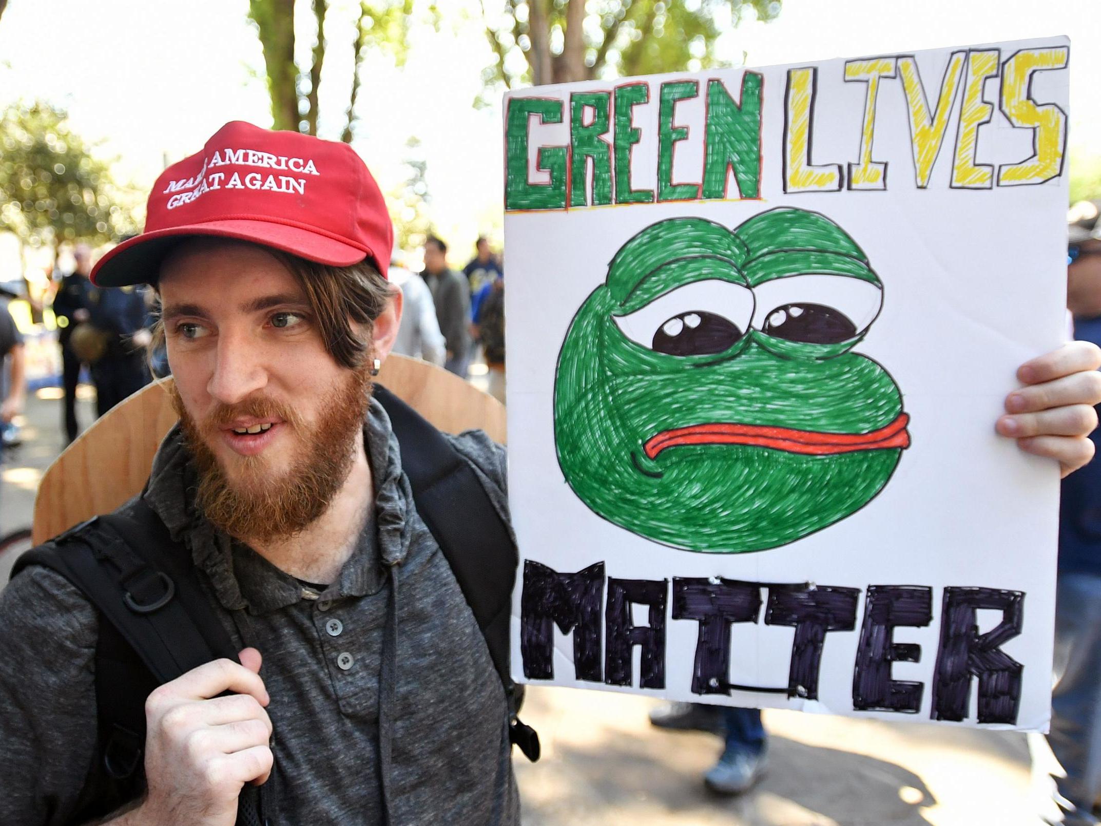 Coded: a protester holds a sign depicting Pepe the frog, during a rally in Berkeley, California