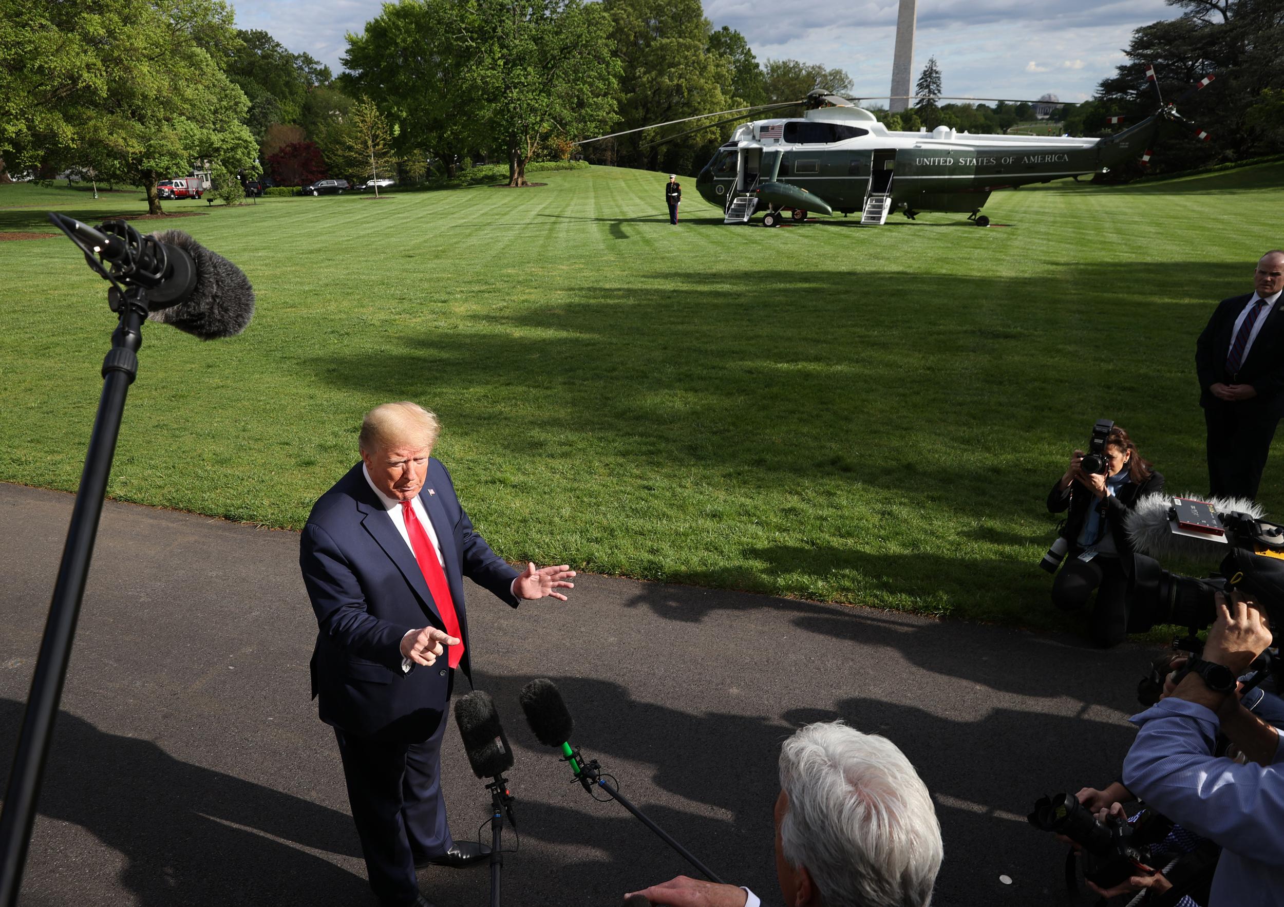 President Donald Trump talks to journalists on the South Lawn while departing the White House for Camp David on 1 May, 2020