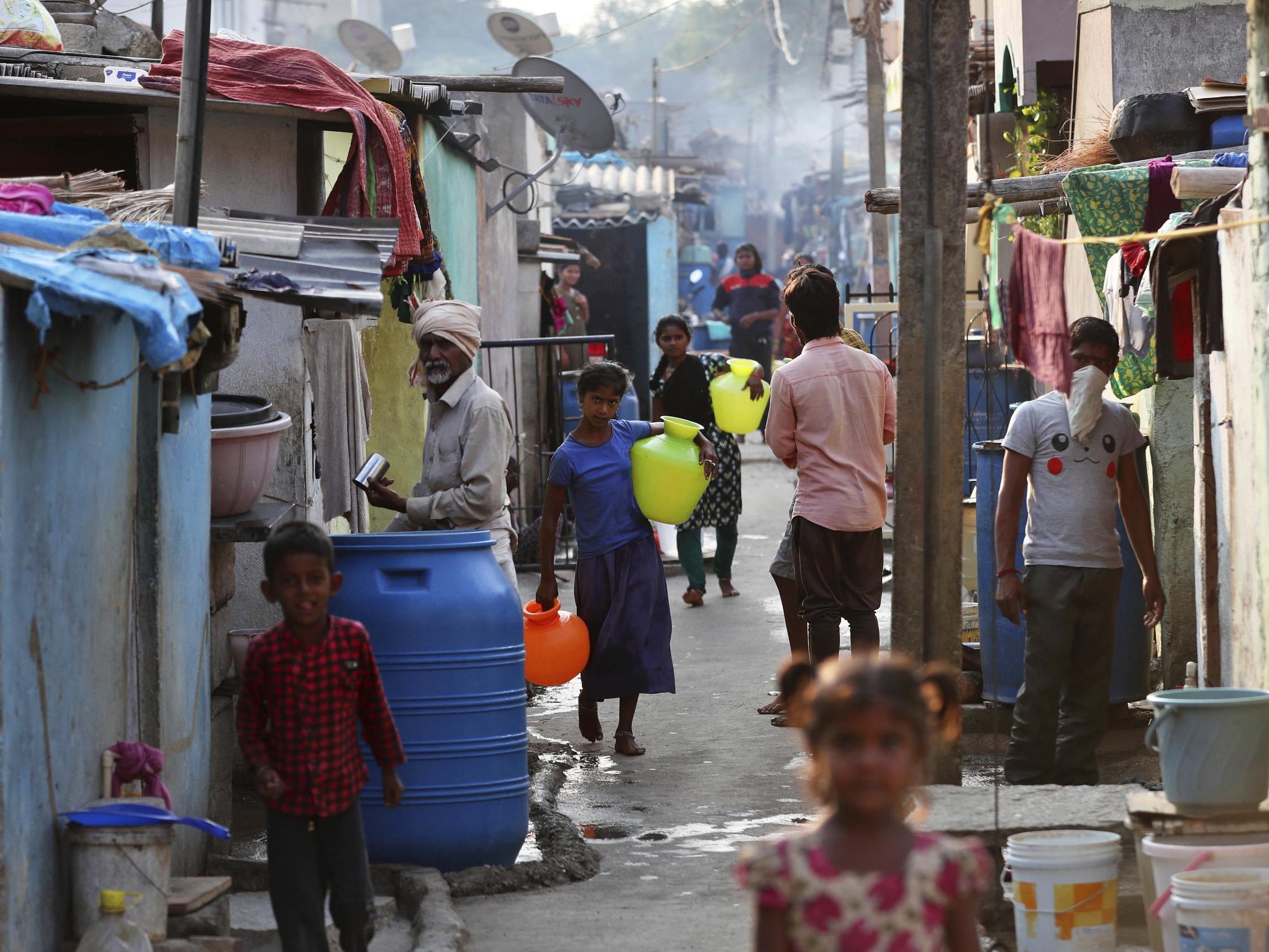 Indians attend to their morning chores in one of the nation's slums during a nationwide lockdown to curb the spread of new coronavirus, in Bangalore, India