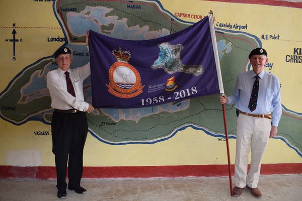 Ron Watson and Robert McCann proudly hold their standard in front of a mural of Kiritimati Island