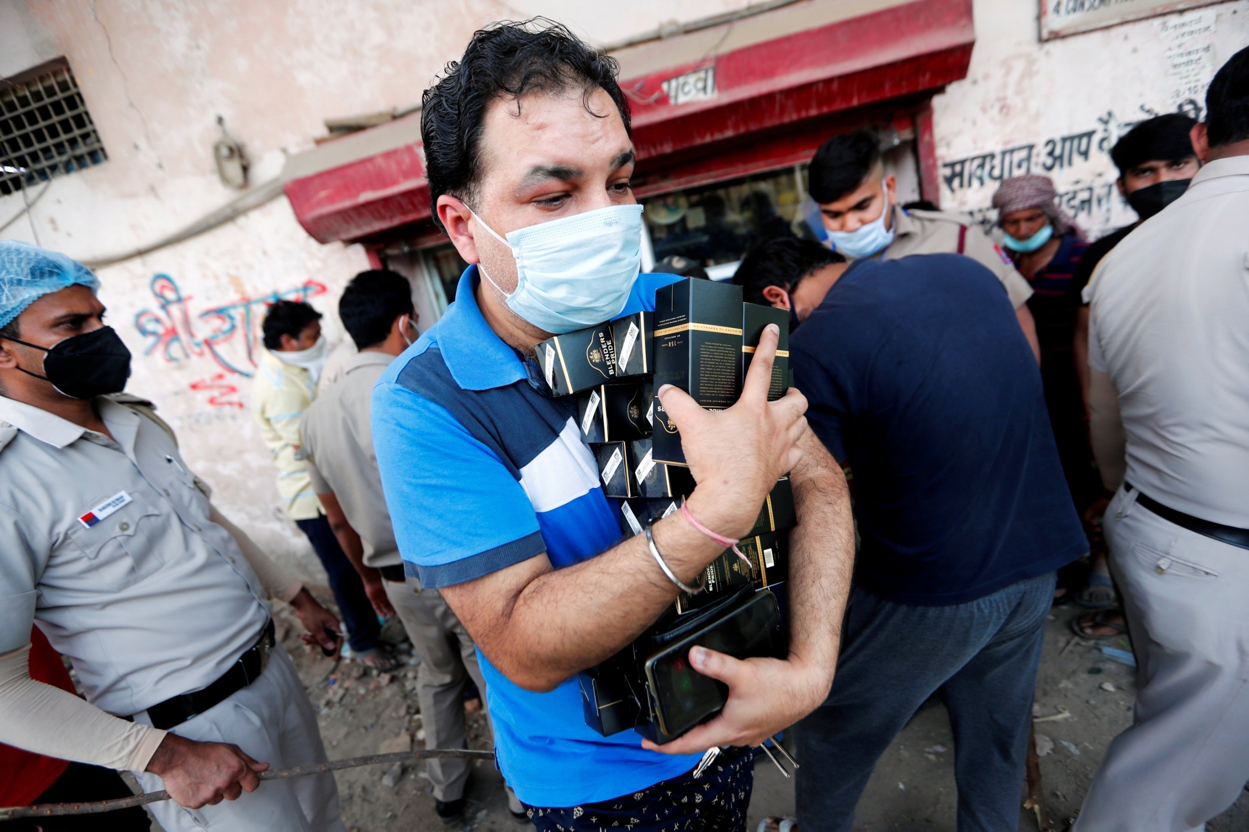 A man stocks up on liquor as wine shops reopen in Delhi, India