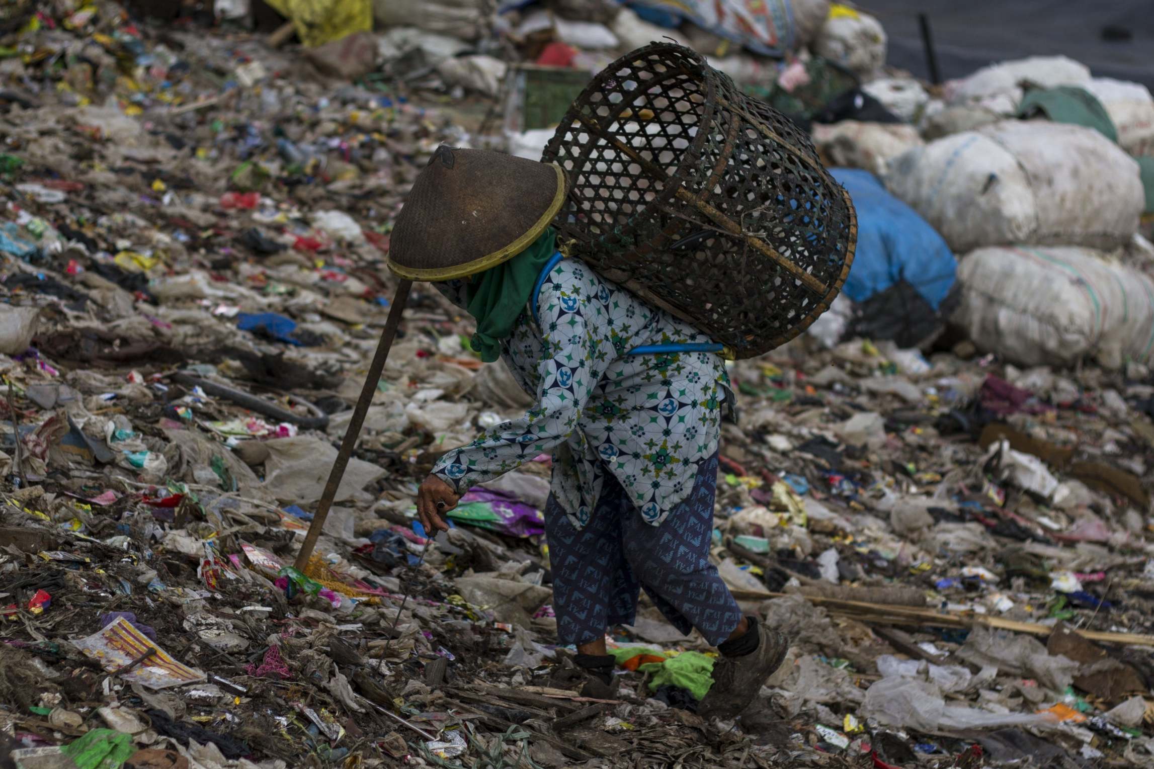A worker on the landfill mountain, looking for what is recyclable