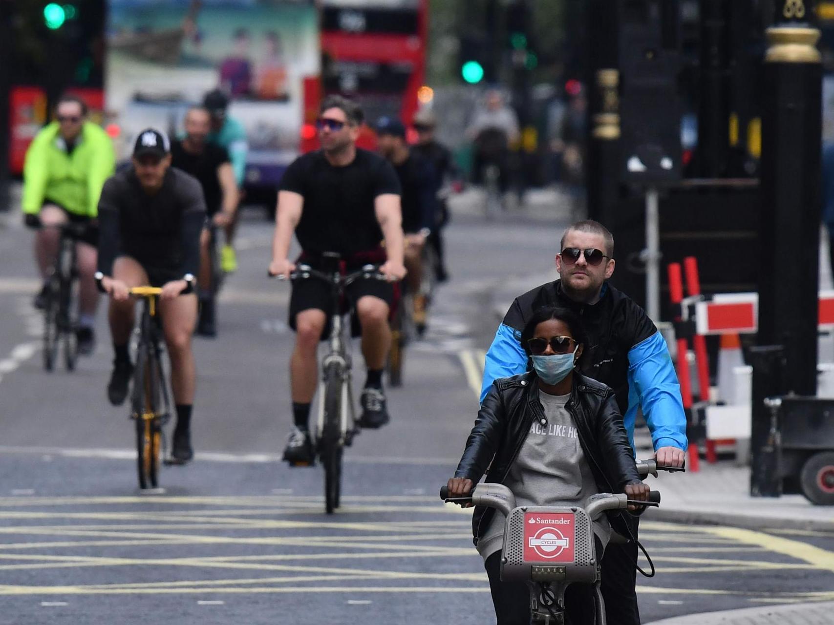 People cycling wearing face masks as a precaution are seen on Oxford Street in London
