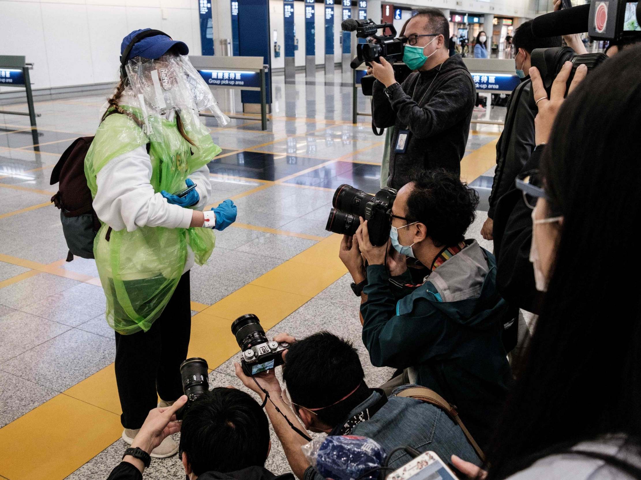 A passenger shows off her quarantine tracking wrist band at Hong Kong’s international airport (AFP/Getty)