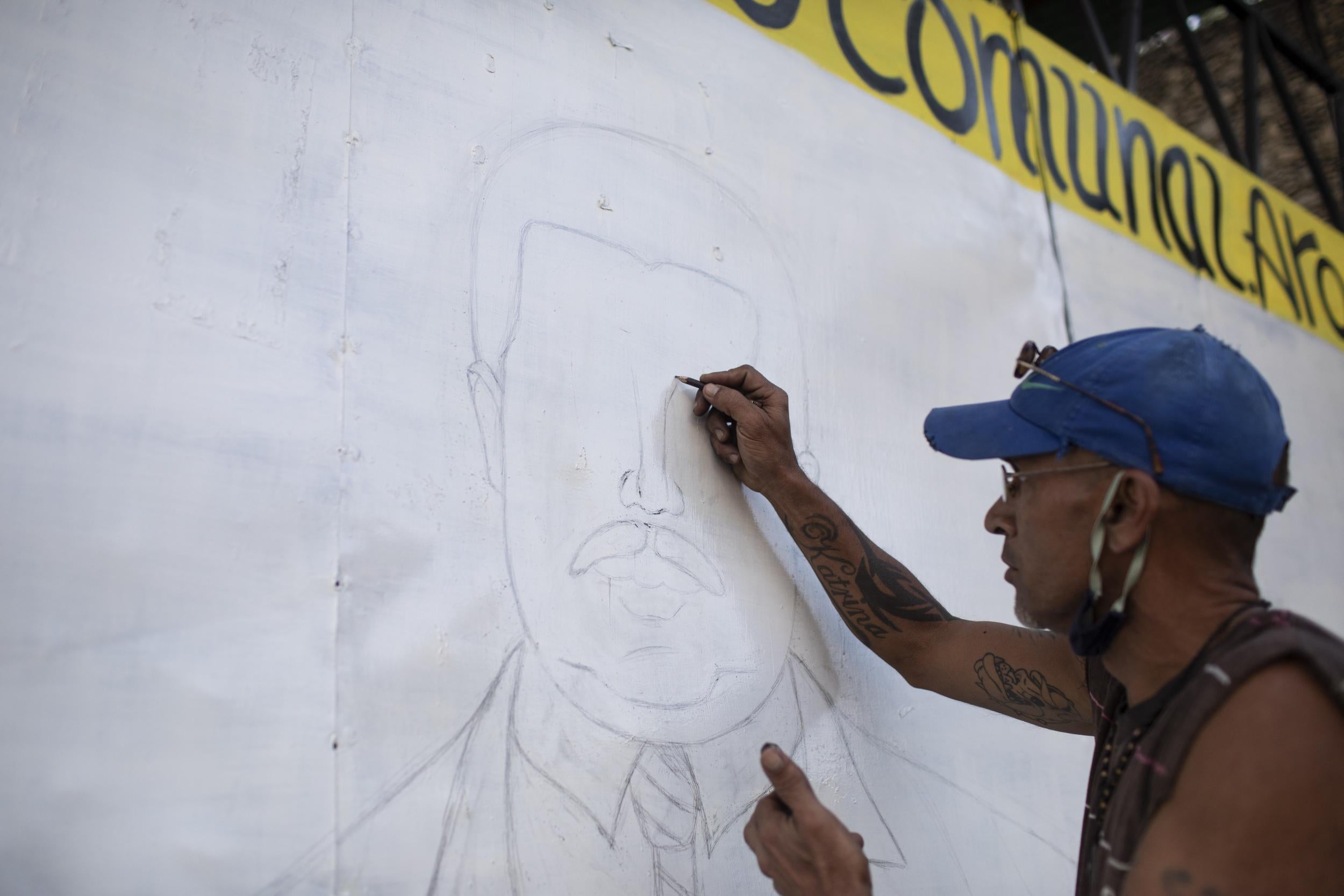 Graffiti artist, Beto Urdaneta, draws a picture on a wall of President of Venezuela Nicolas Maduro