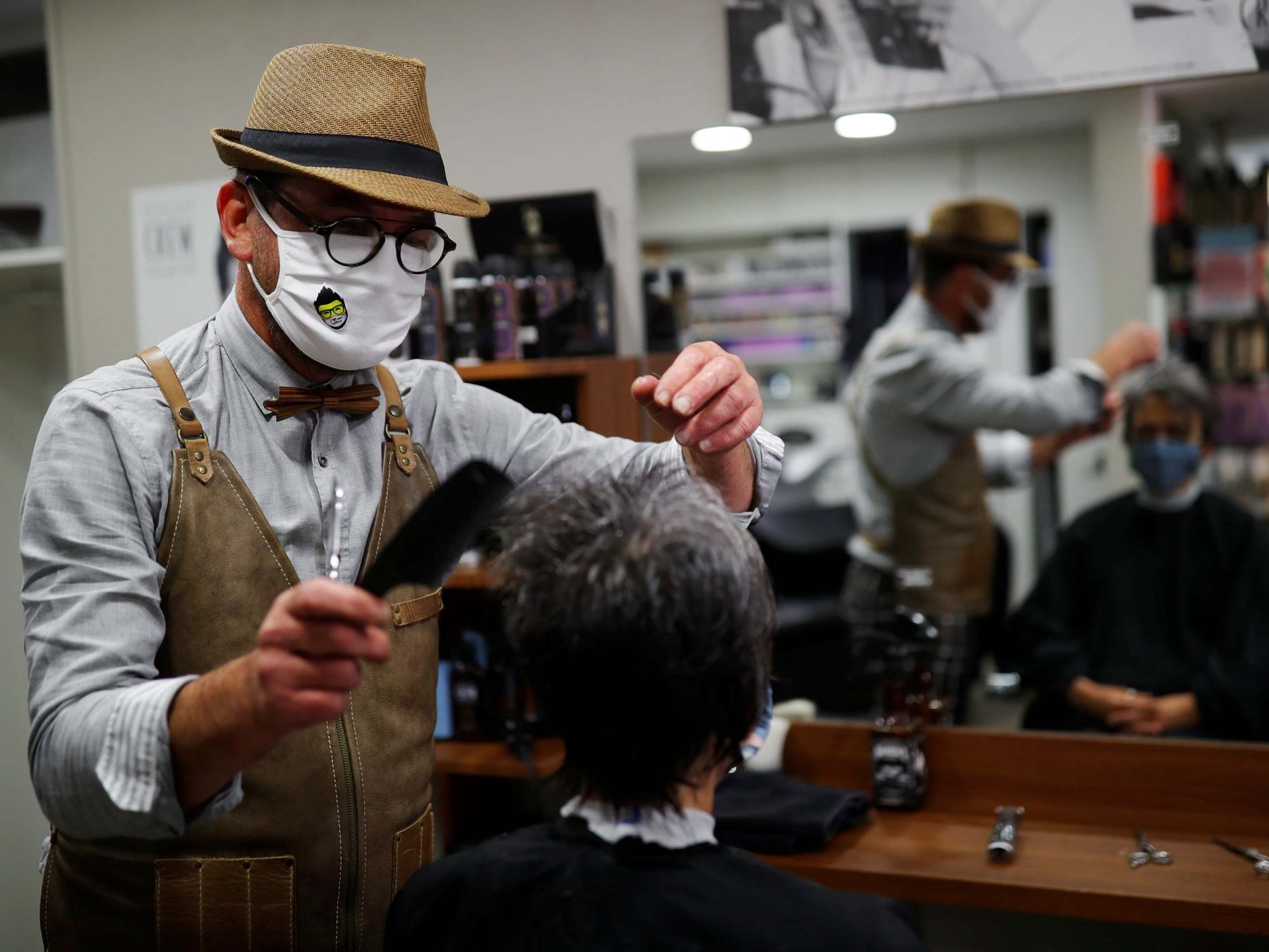 French hairdresser Marc Mauny tends to his first customer during the midnight reopening of his salo in Mayenne