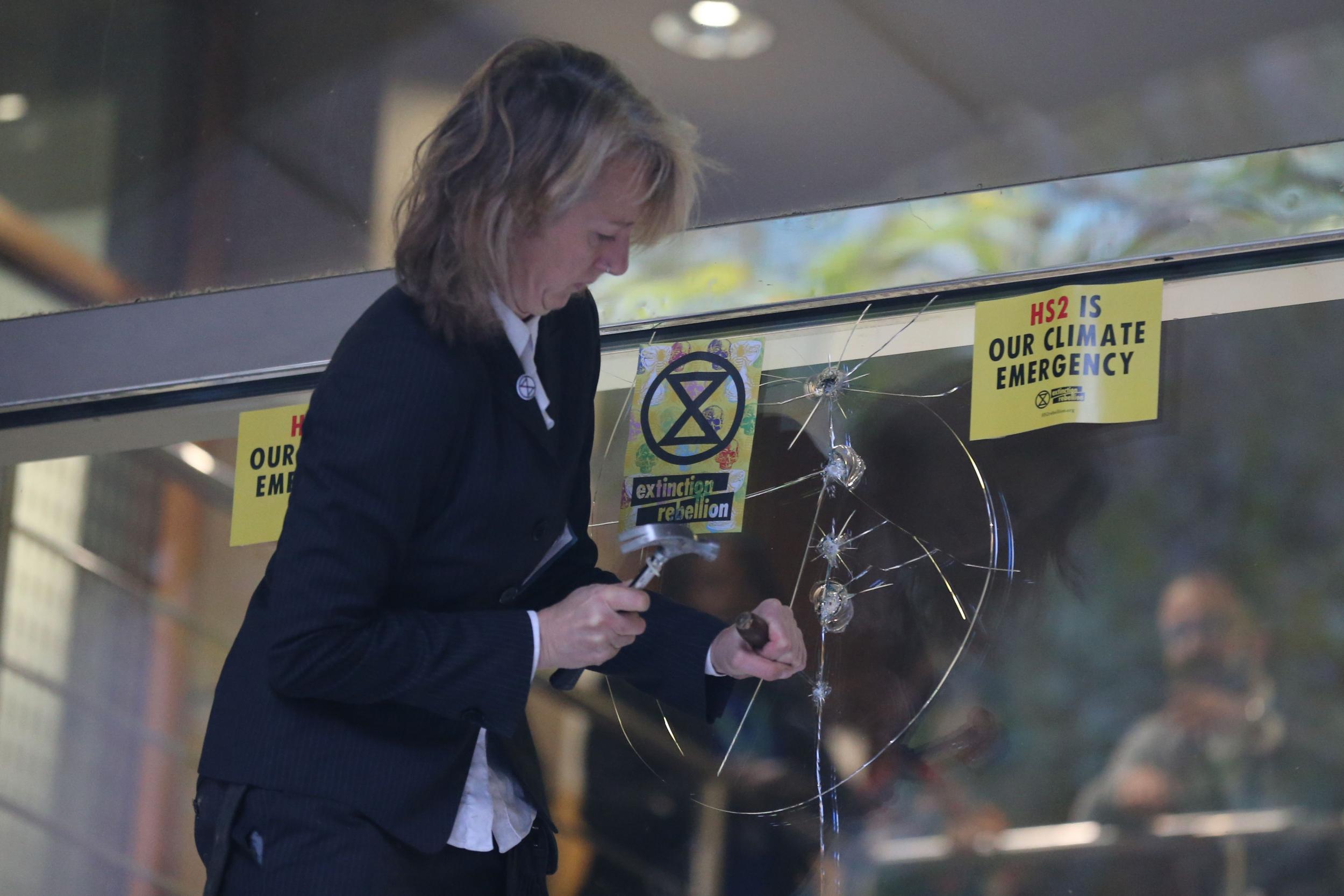 Co-founder of XR Gail Bradbrook smashes a window at the headquarters of the Department for Transport in central London during the group’s ‘autumn uprising’