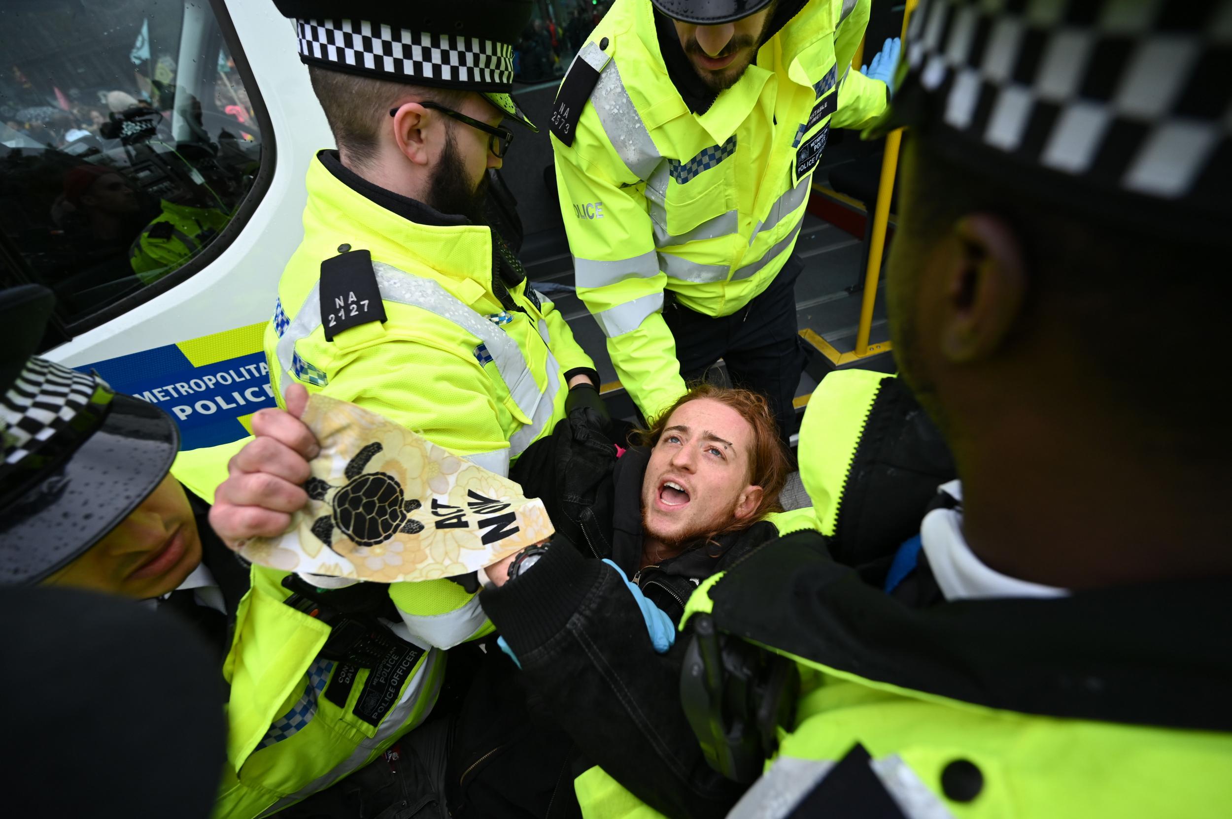 Police detain an XR protestor during demonstrations in Trafalgar Square in October