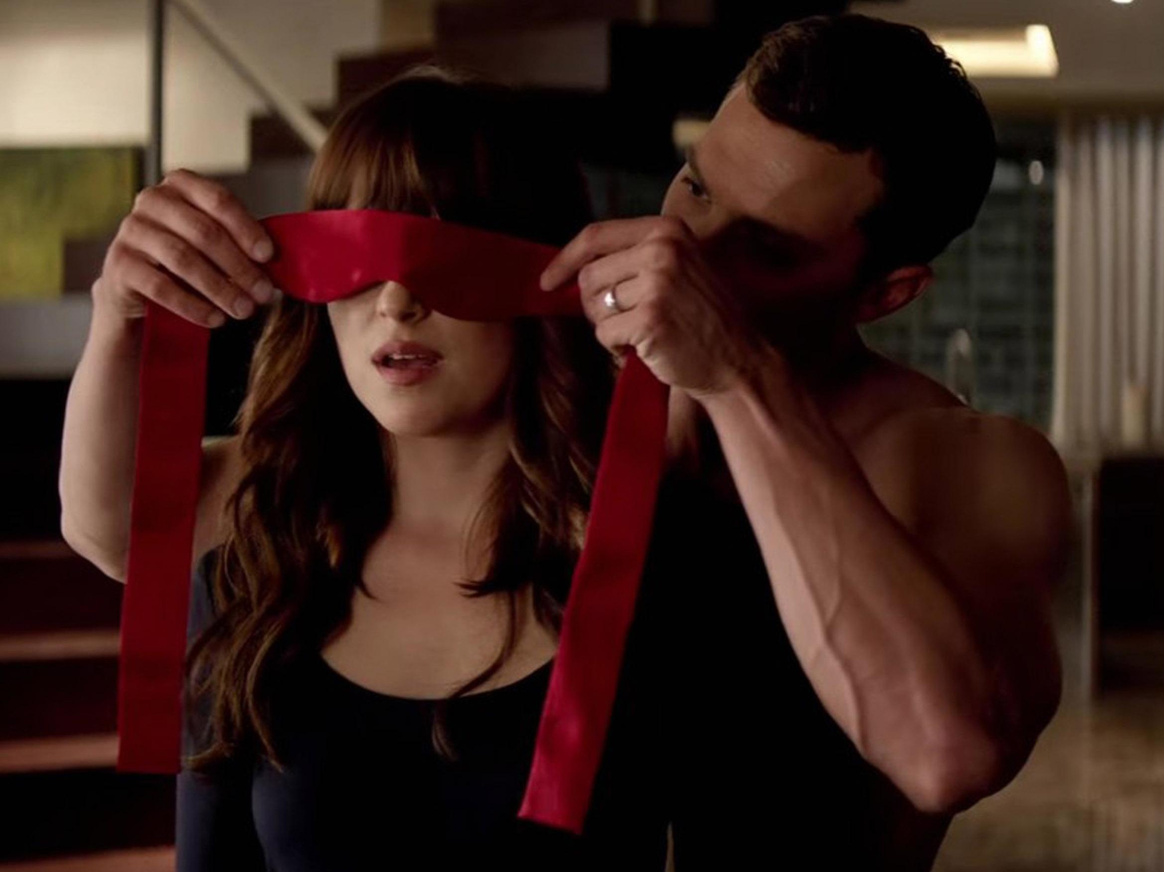 Christian Grey puts Ana Steele in a blindfold in ‘Fifty Shades of Grey’