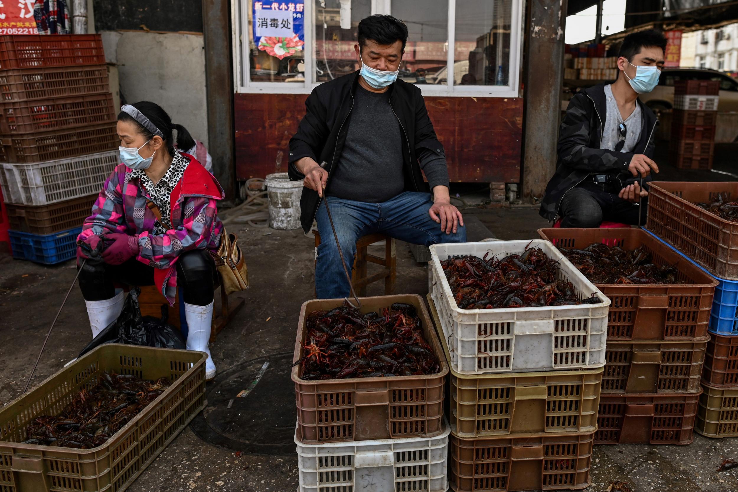 Vendors at a wet market in Wuhan, thought to be the origin of the virus late last year