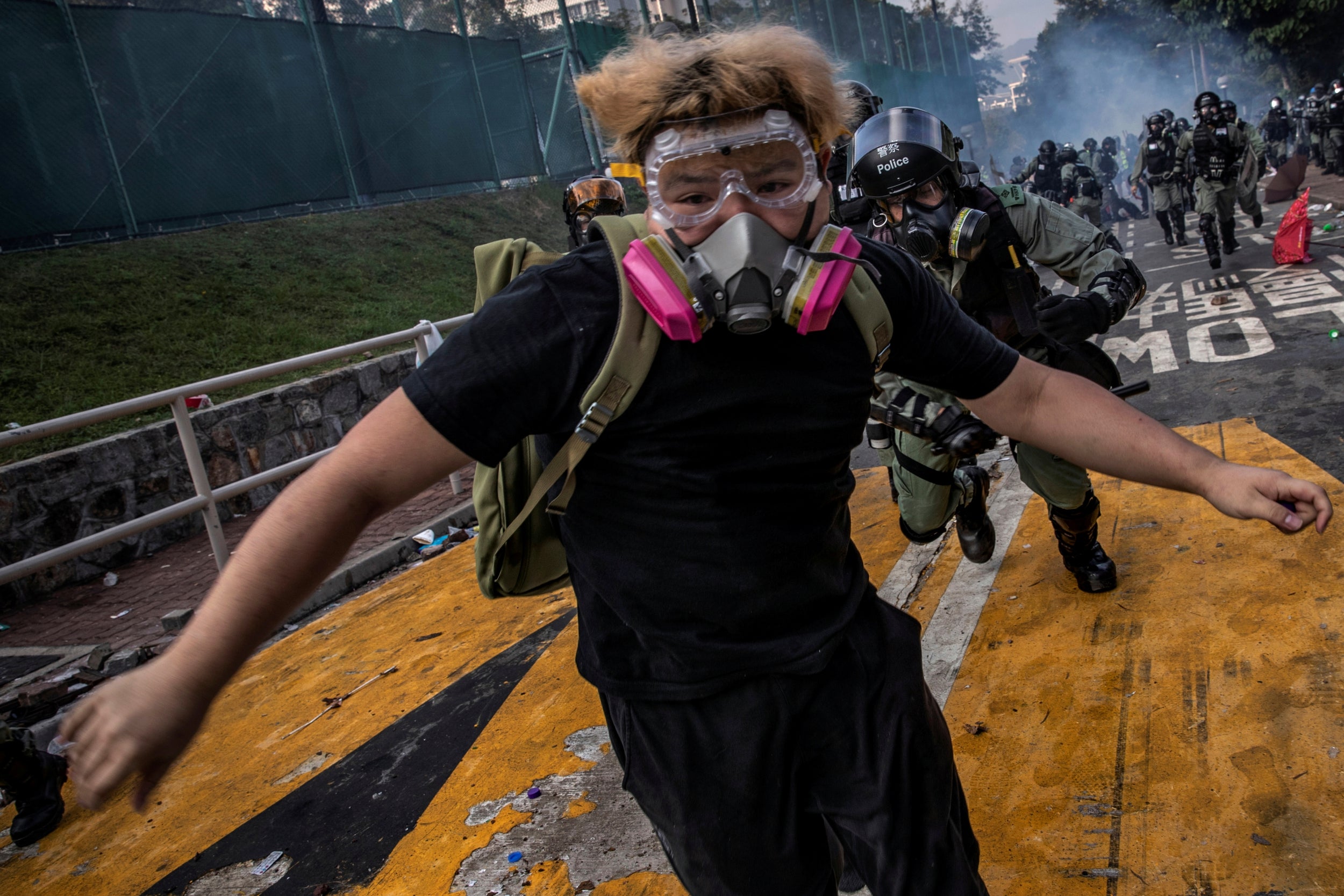 A demonstrator is chased by policemen