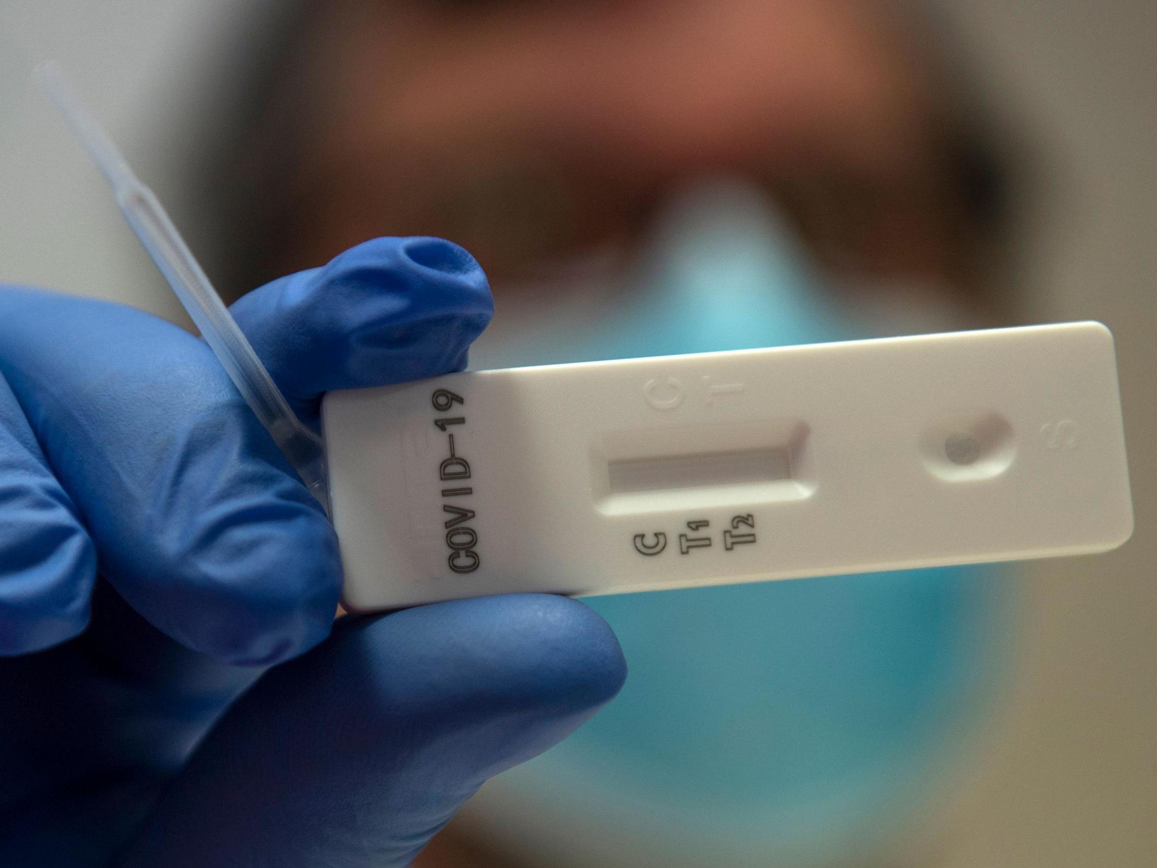 A medical worker shows an antibody rapid serological test for Covid-19, on 6 May, 2020