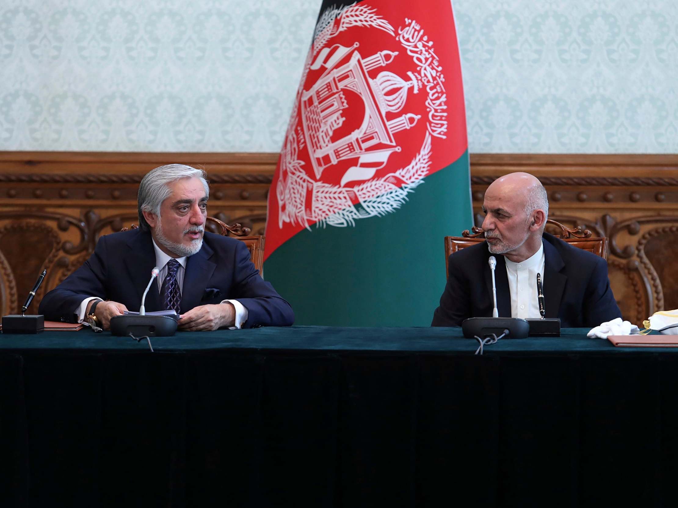 Afghan president Ashraf Ghani, right, and political rival Abdullah Abdullah speak after they signed a power-sharing agreement at the presidential palace in Kabul