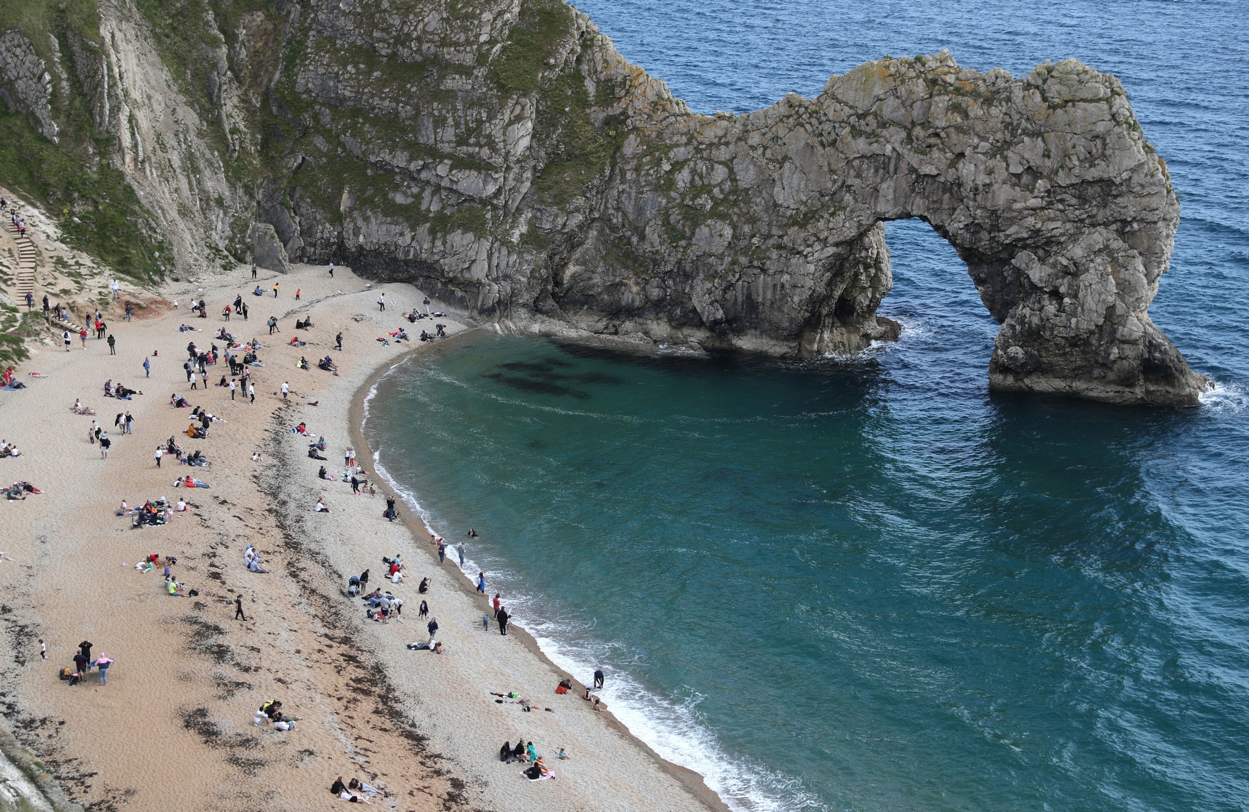 Beachgoers enjoy the sun at Durdle Door in Dorset