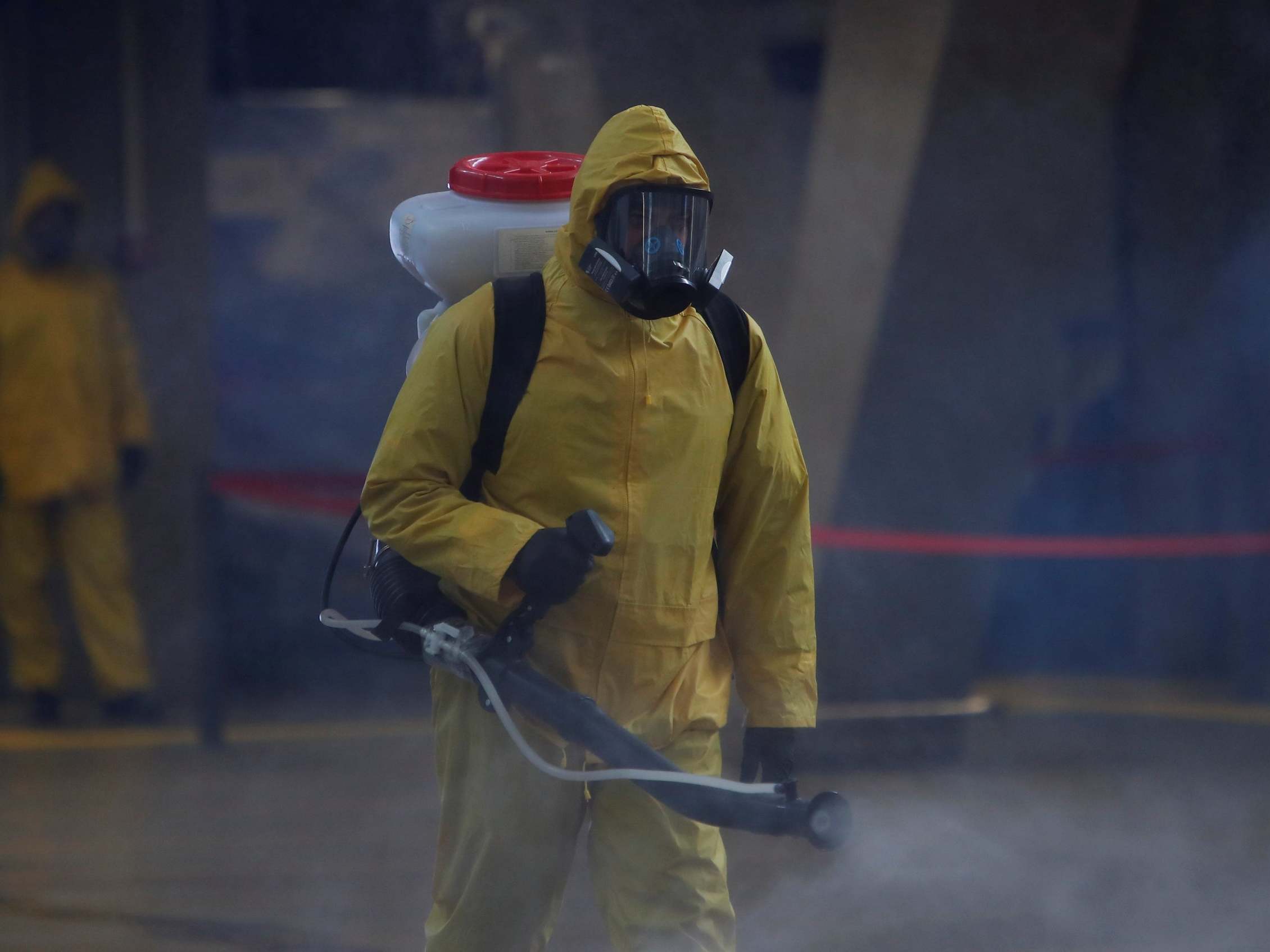 A member of the Russian emergencies ministry sprays disinfectant while sanitising the Leningradsky railway station in Moscow