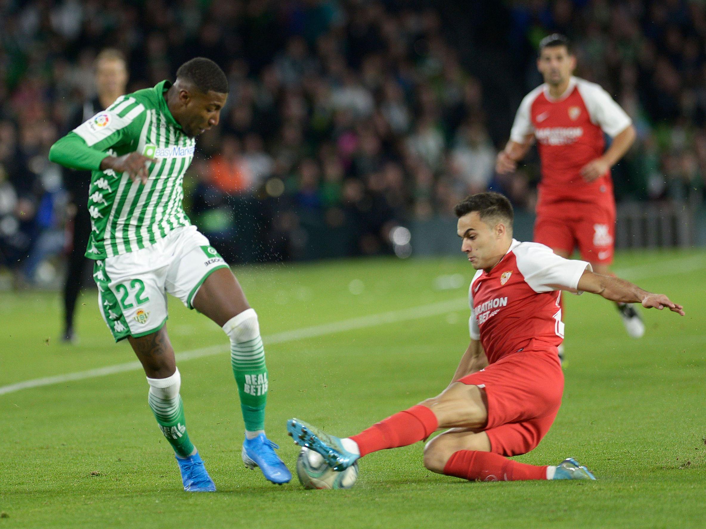 Real Betis' Emerson Aparecido (L) fights for the ball with Sevilla's Sergio Reguilon