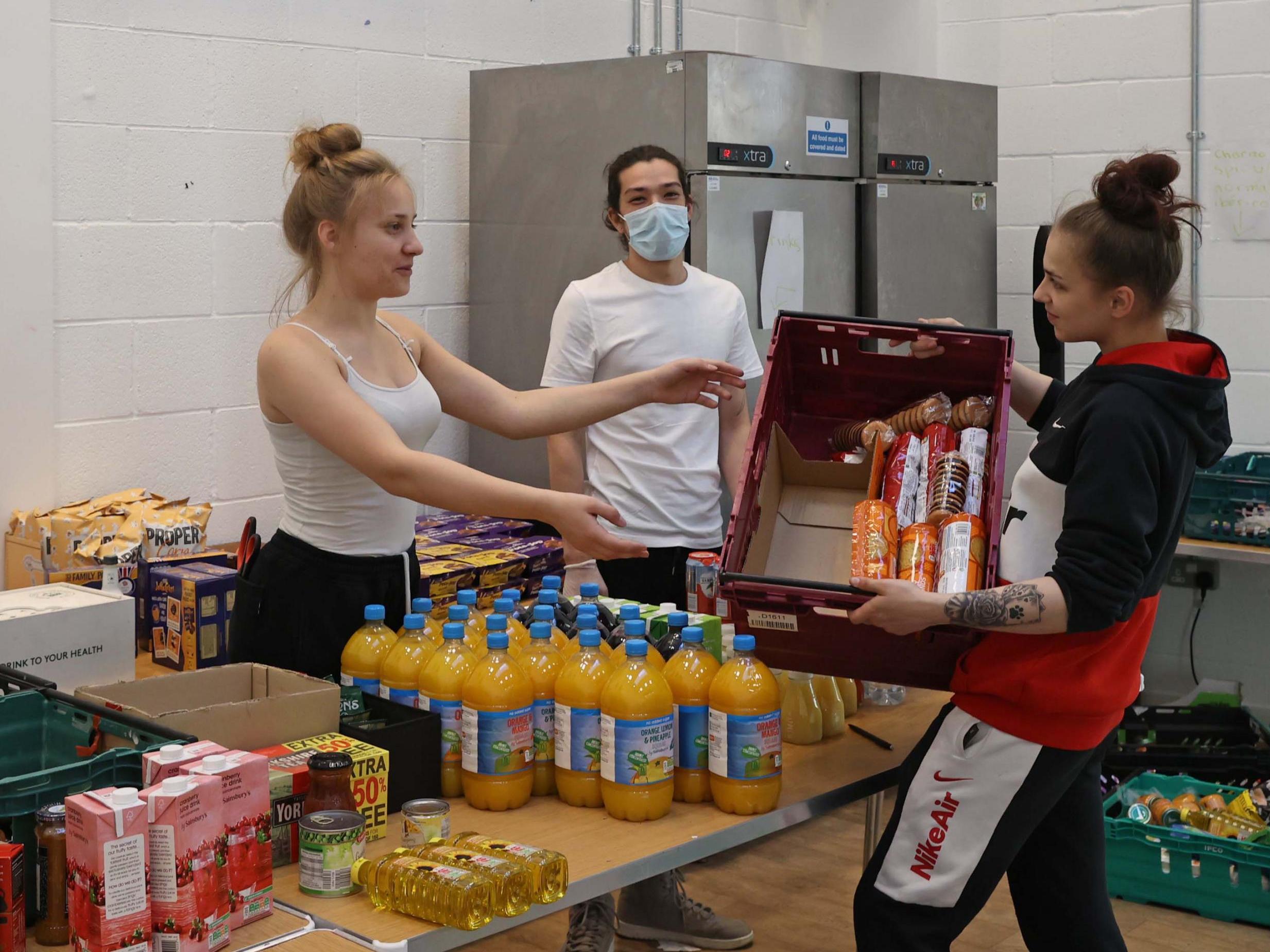 Volunteers AJ, 15, (left) and Lara, 17 (right), in South Acton help pack boxes of goods from The Felix Project, our Help The Hungry campaign partner