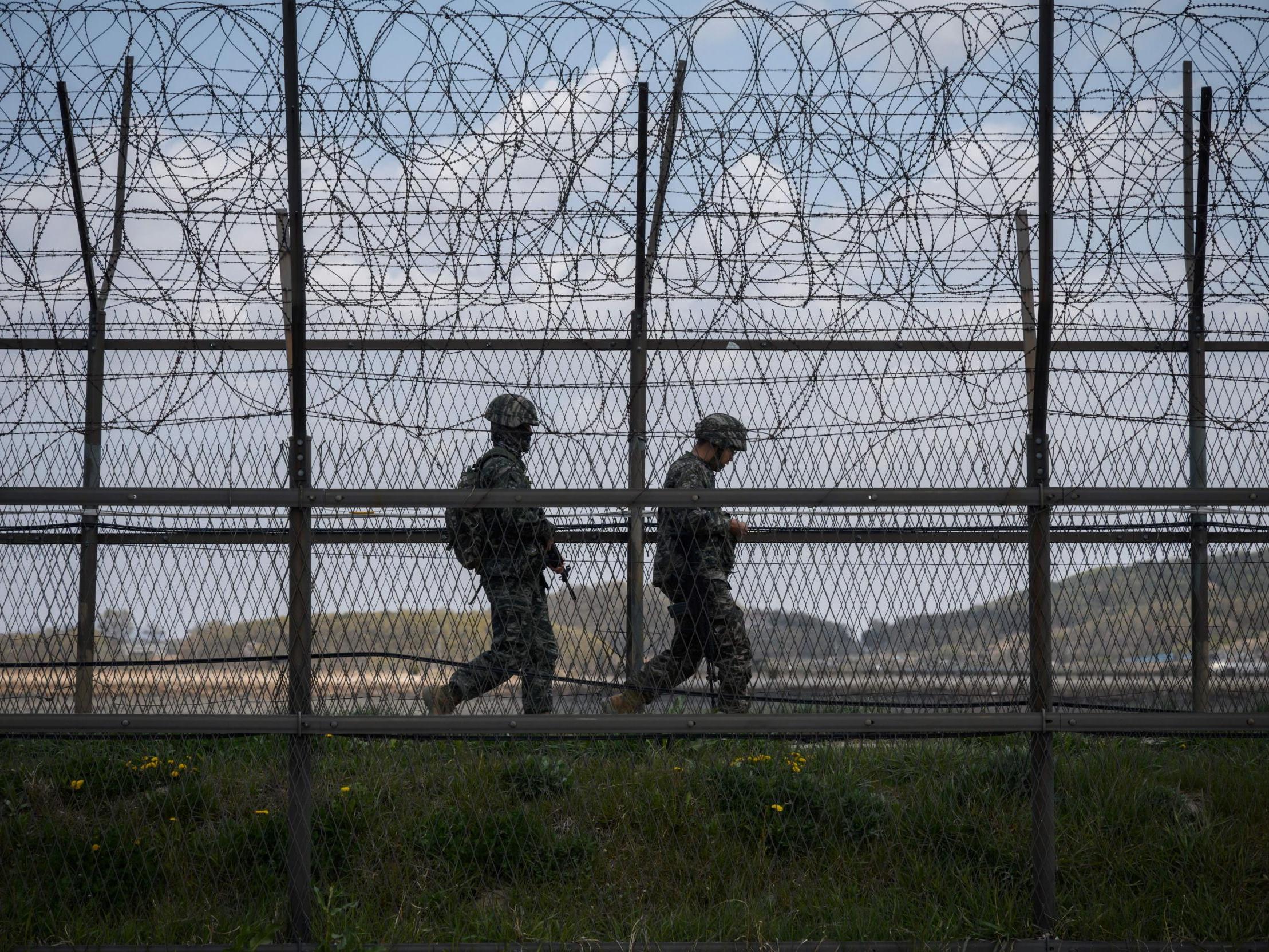 South Korean soldiers patrol along a barbed wire fence Demilitarized Zone (DMZ) separating North and South Korea, on the South Korean island of Ganghwa