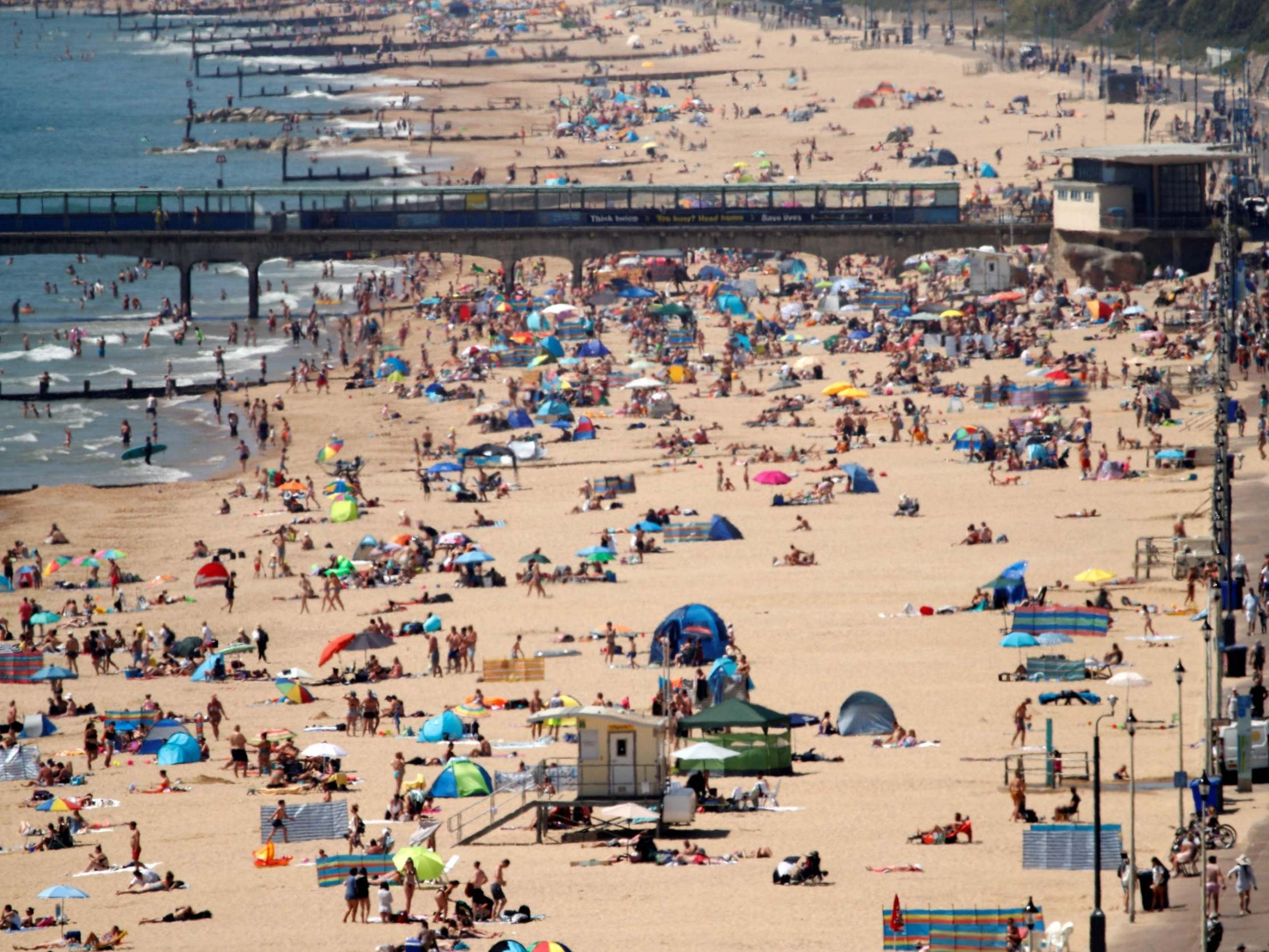 Sunbathers enjoy the warm weather on the beach near Boscombe Pier