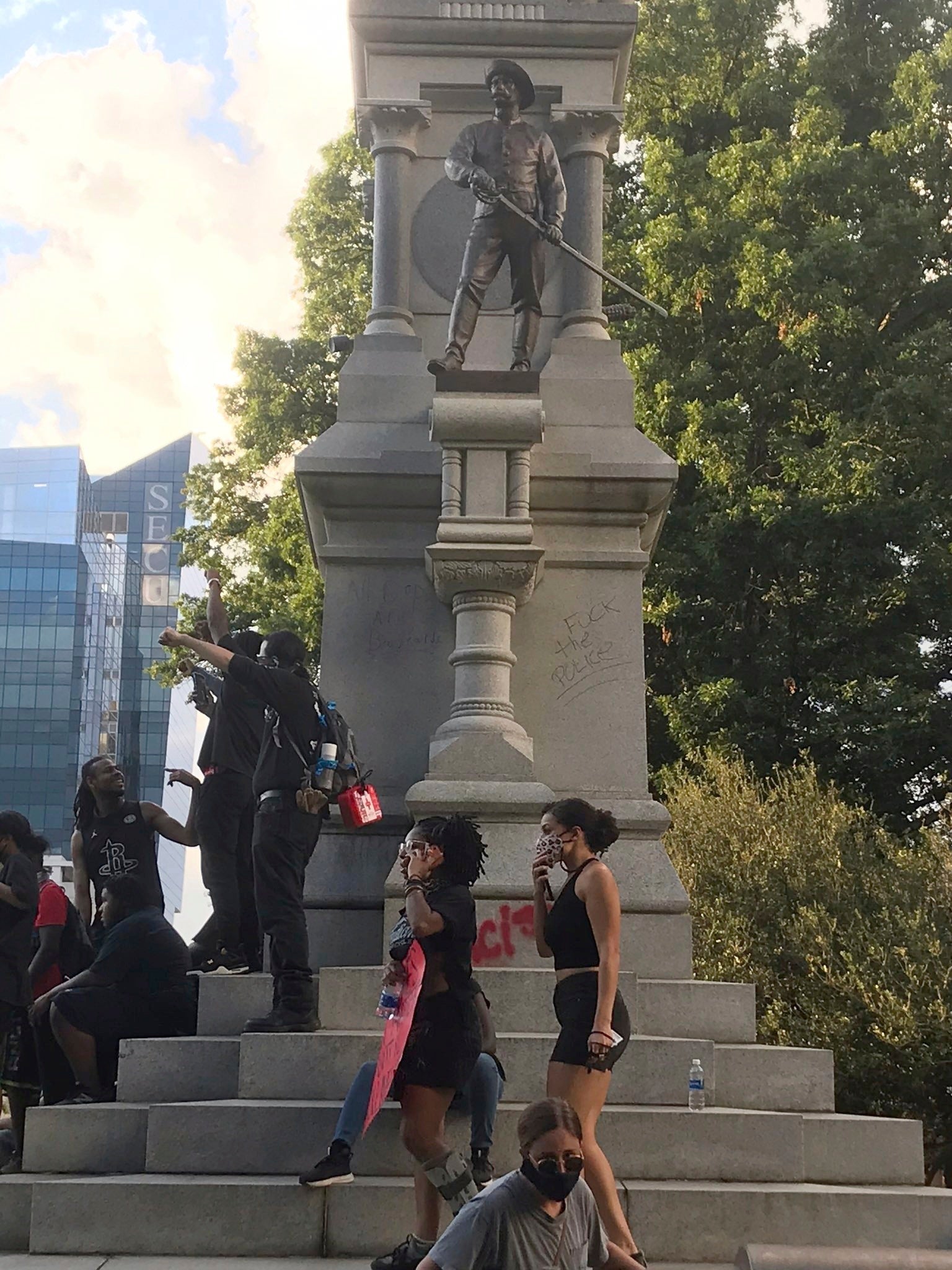Protesters gather around a Confederate monument in North Carolina's capital