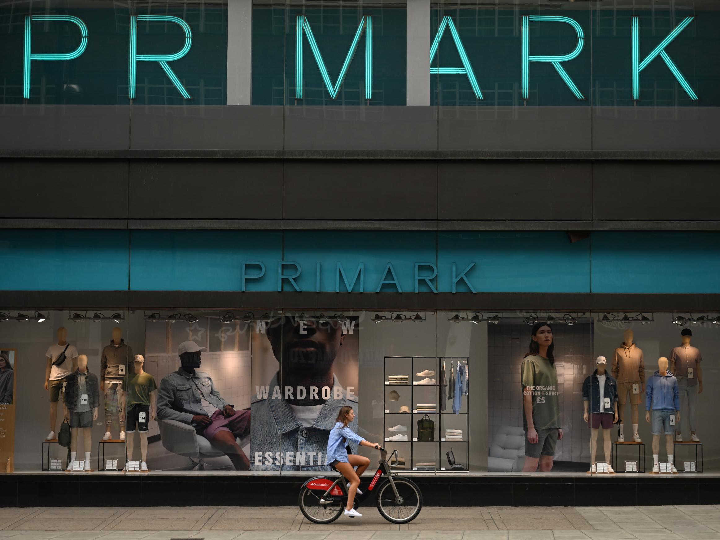 A woman cycles passed a shut Primark store on Oxford Street, London