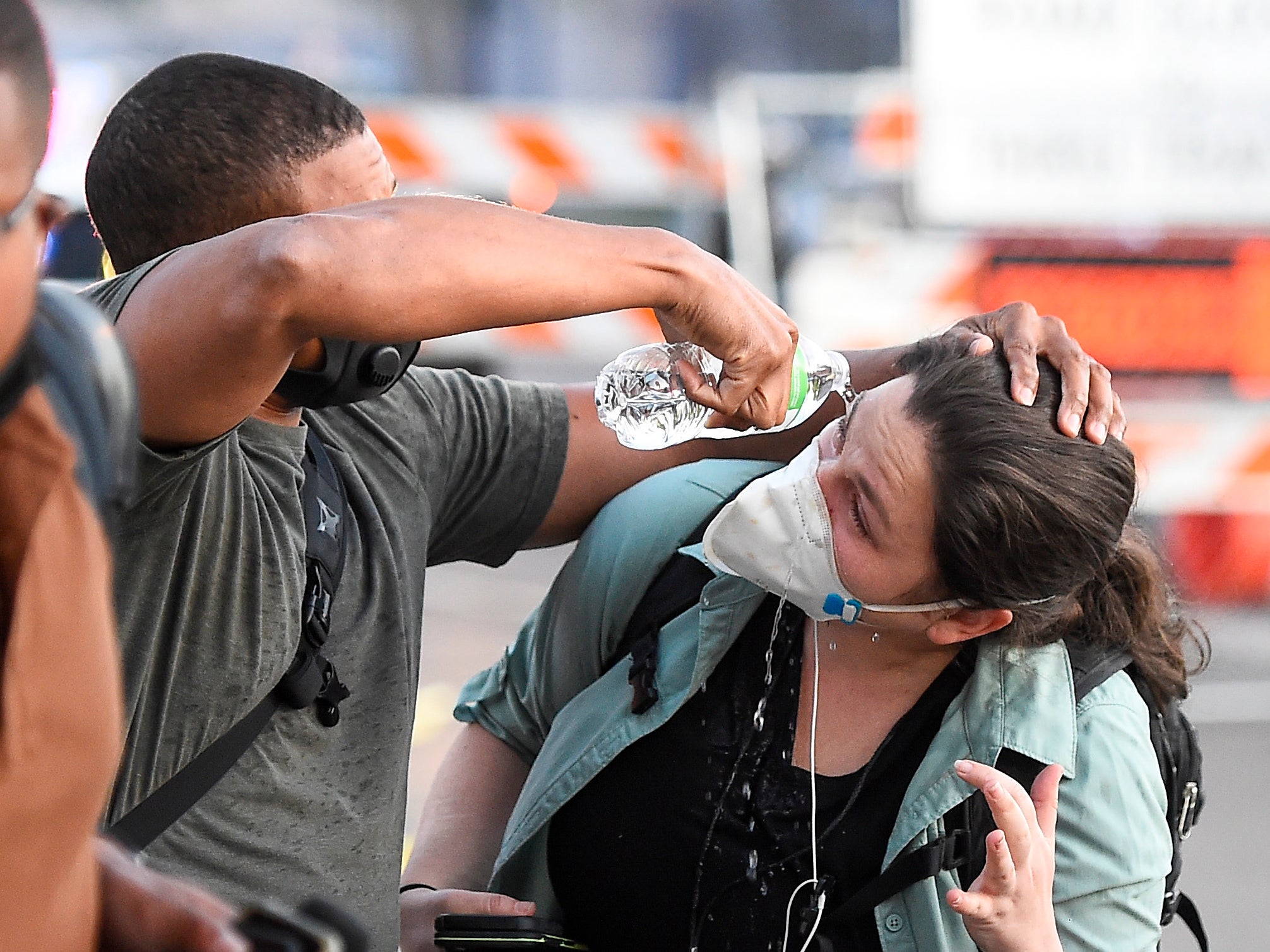 A reporter has her eyes rinsed to clear the effects of teargas thrown by Minneapolis police
