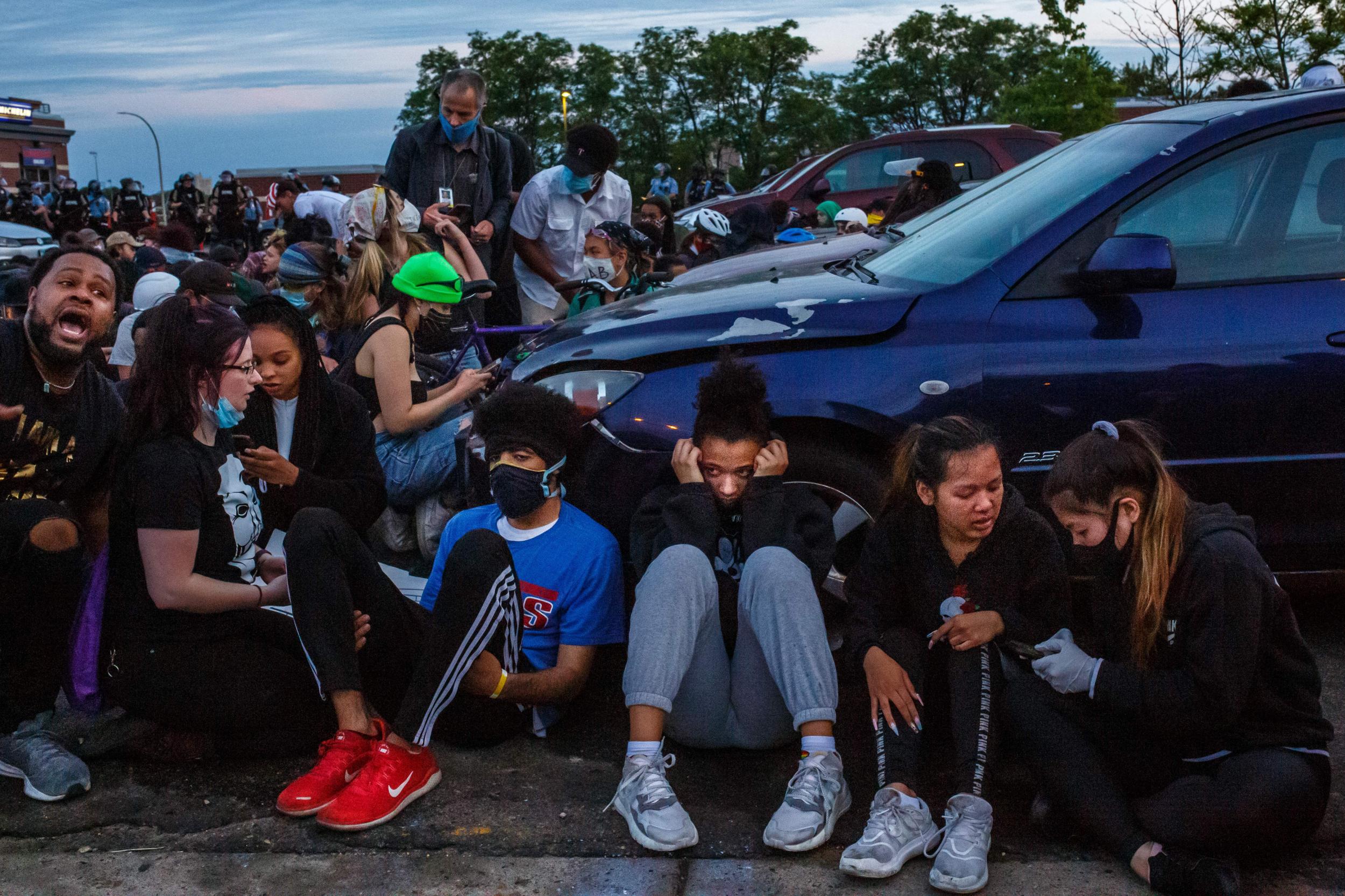 The Independent's Andrew Buncombe, in blue mask, interviews protesters as they are arrested in Minneapolis