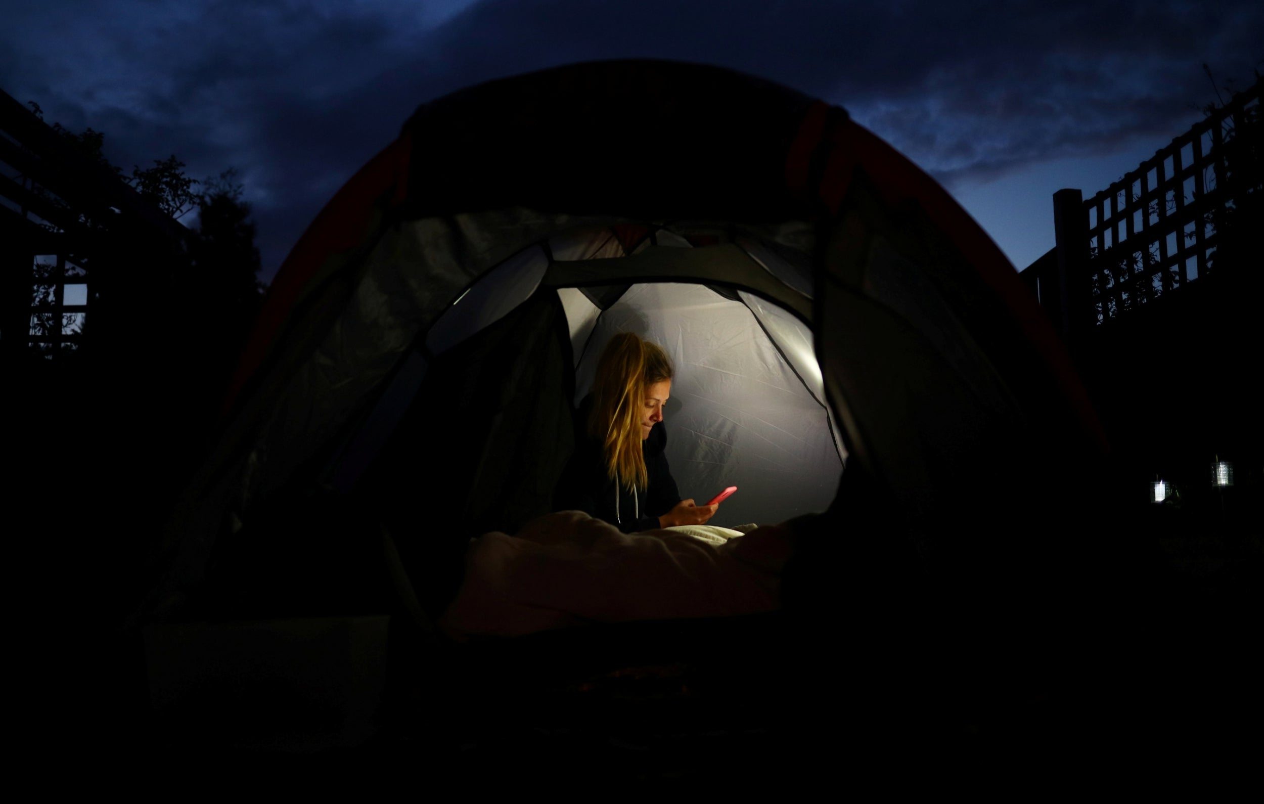 McKay sends a message from her mobile phone from a tent she is staying in overnight