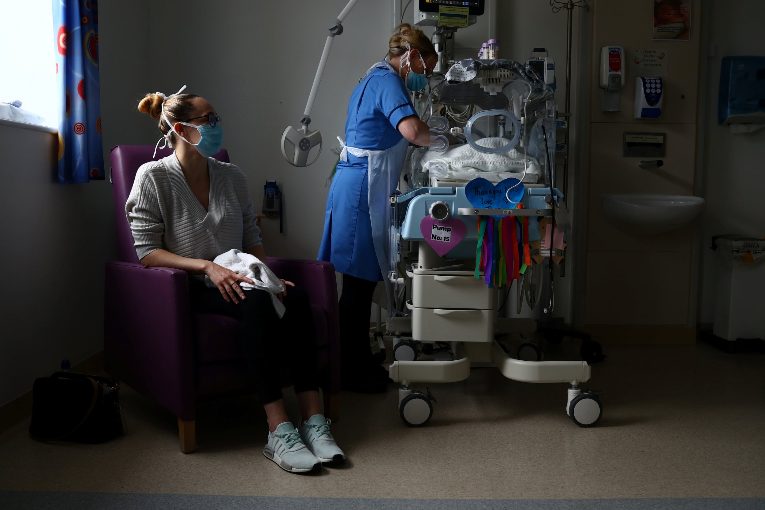 Neonatal nurse Kirsty Hartley cares for premature baby Theo, as his mother Kirsty Anderson looks on