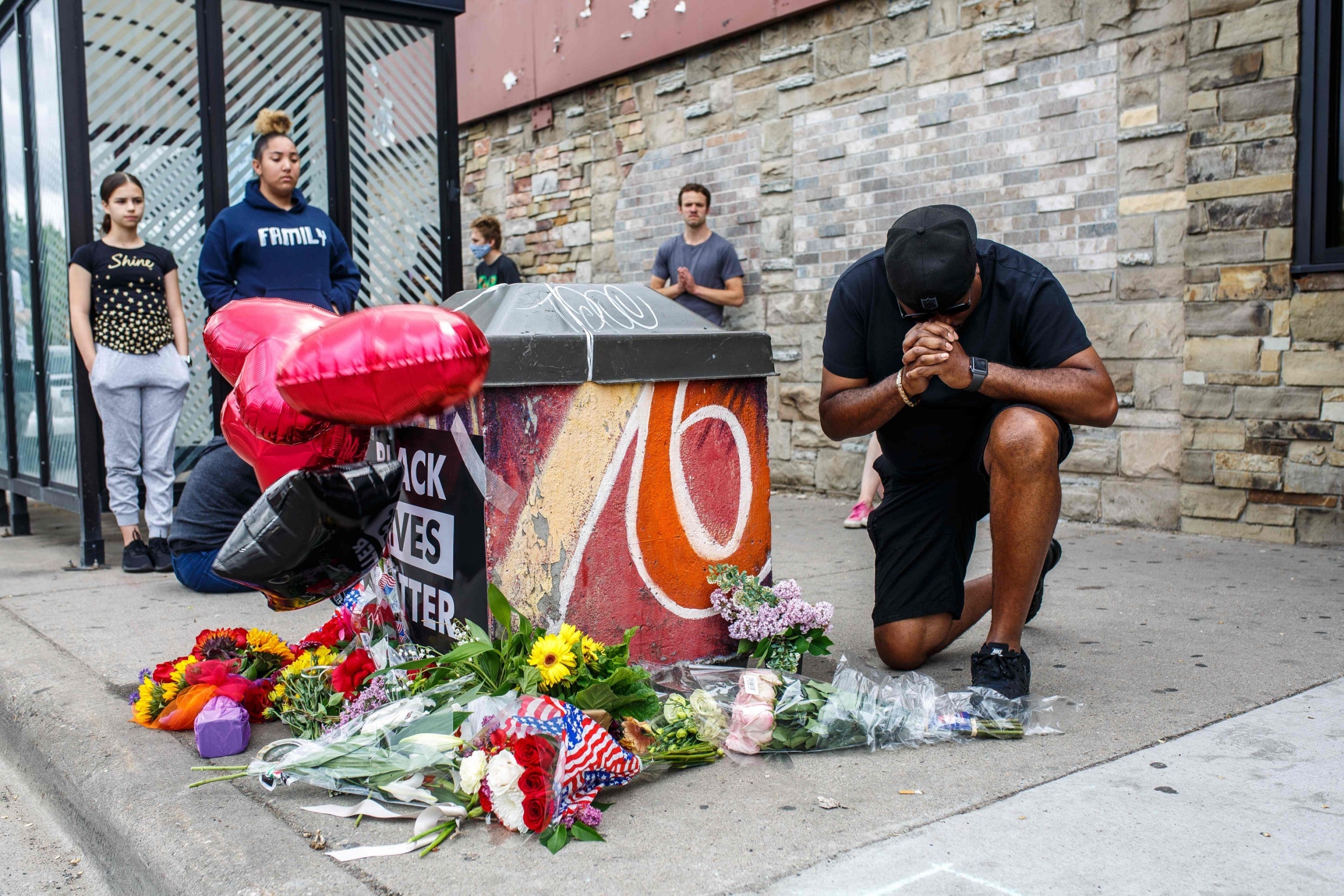 A protester prays in front of George Floyd's memorial in Minneapolis