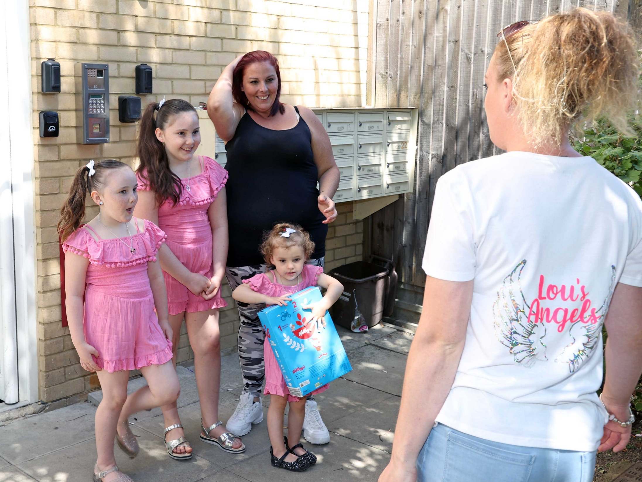 Becca Archer with her three daughters, given a food donation from volunteer Katie-Louise Barber