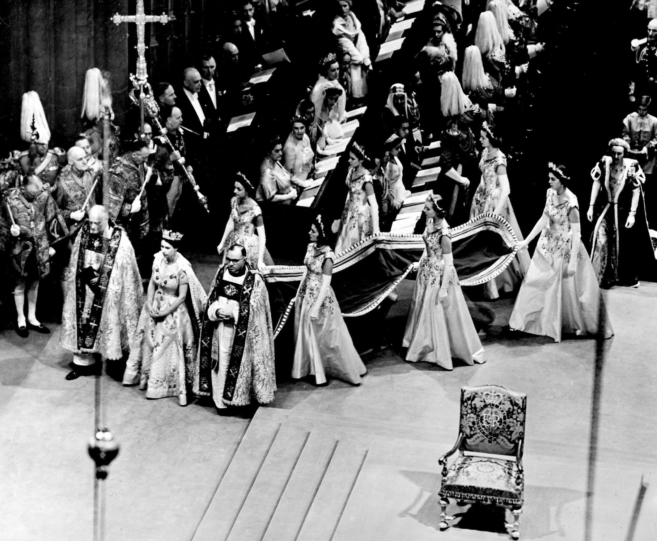 The Queen arrives at Westminster Abbey with her six Maids-of-Honour. She walks beside the Bishop of Durham (on her right) and the Bishop of Bath