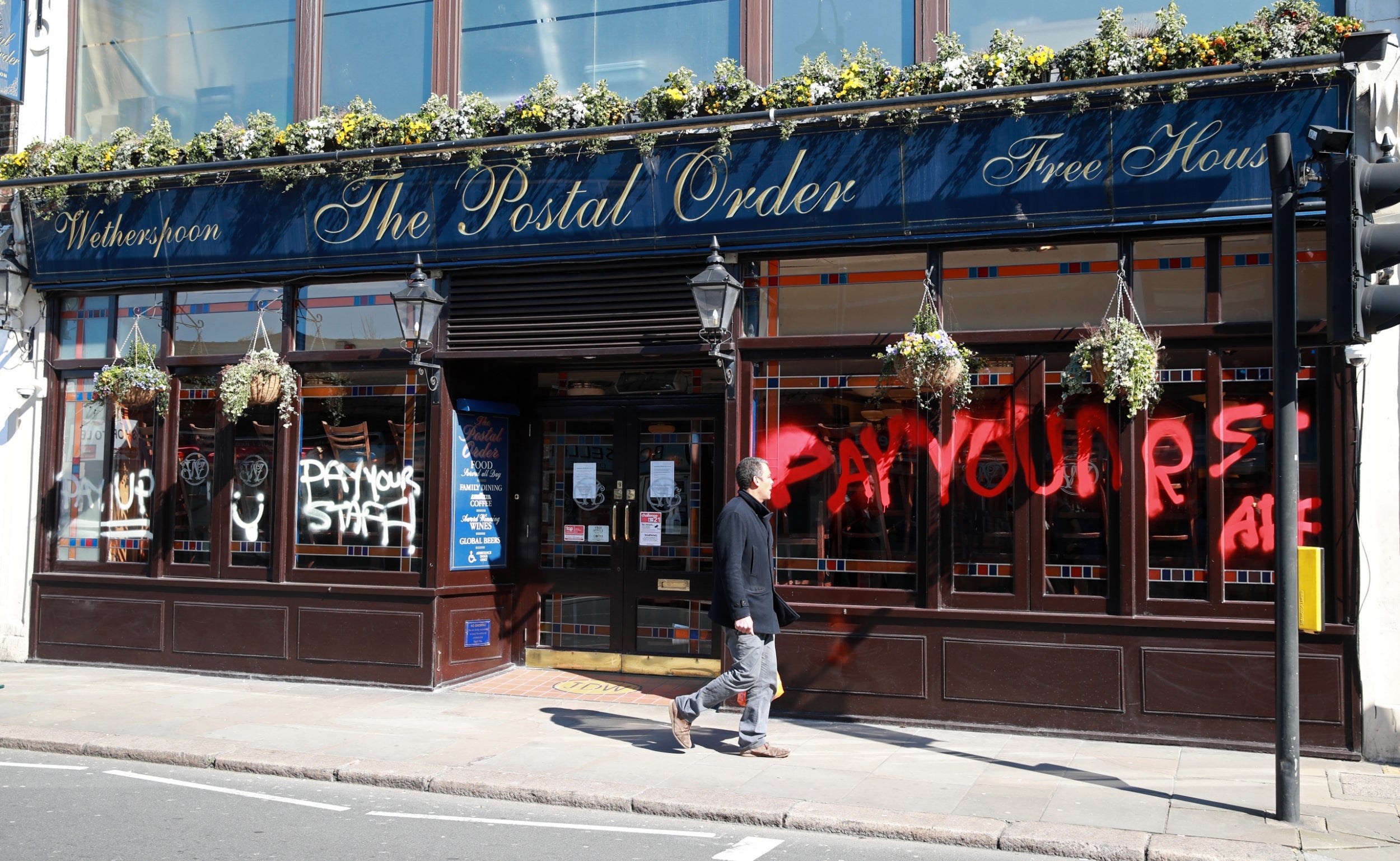 A graffitied Wetherspoon in Crystal Palace. Workers have described founder Tim Martin’s lack of support for his chain’s 40,000 employees as ‘absolutely outrageous’