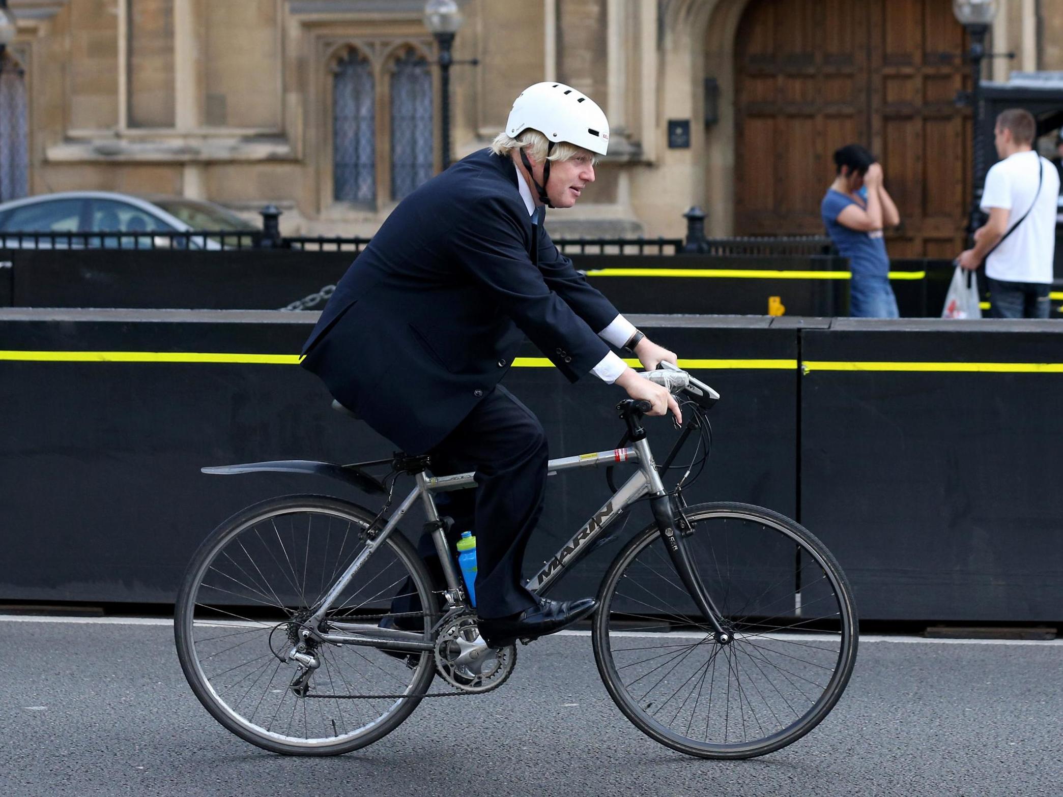 Boris Johnson cycles past the Houses of Parliament in 2013 during his second term as mayor of London