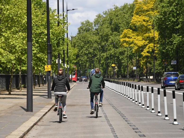 People ride bicycles in a pop-up cycle lane in Park Lane, London