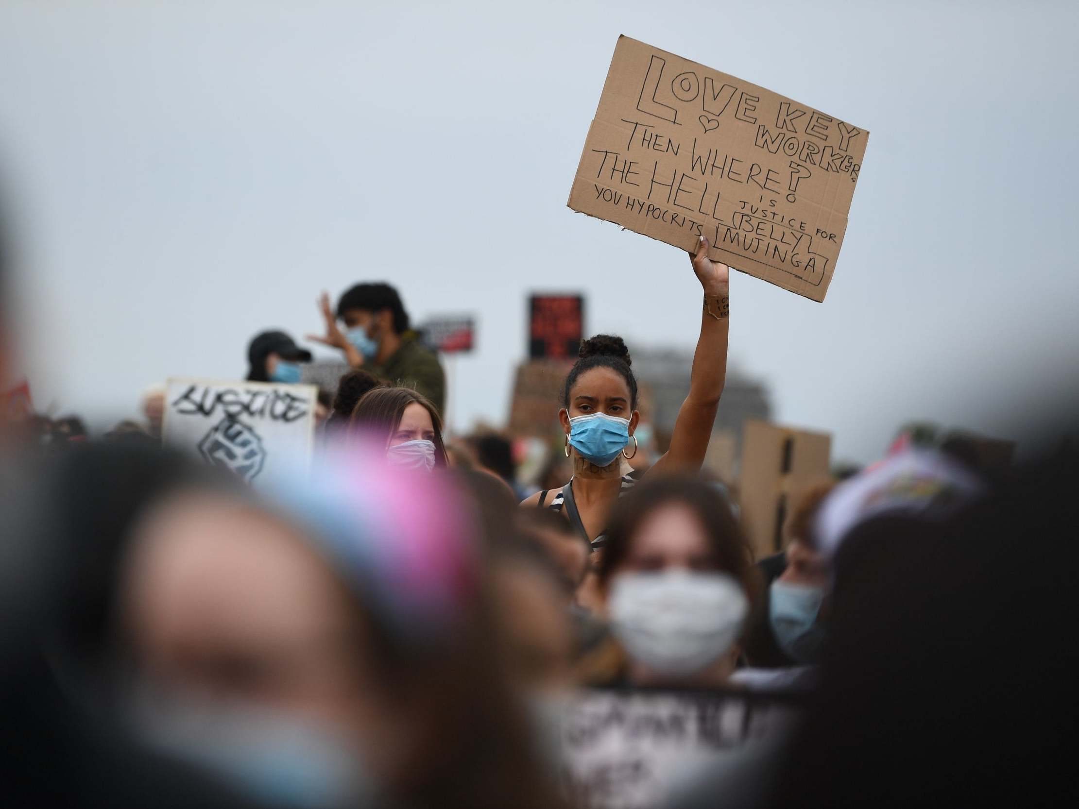 A woman holds up a sign during a Black Lives Matter protest rally in Hyde Park