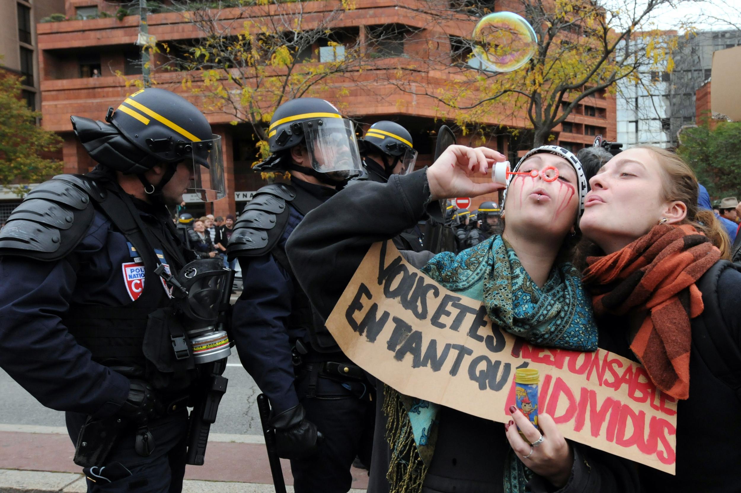 Demonstrators blow bubbles next to anti-riot policemen in Toulouse, southwestern France